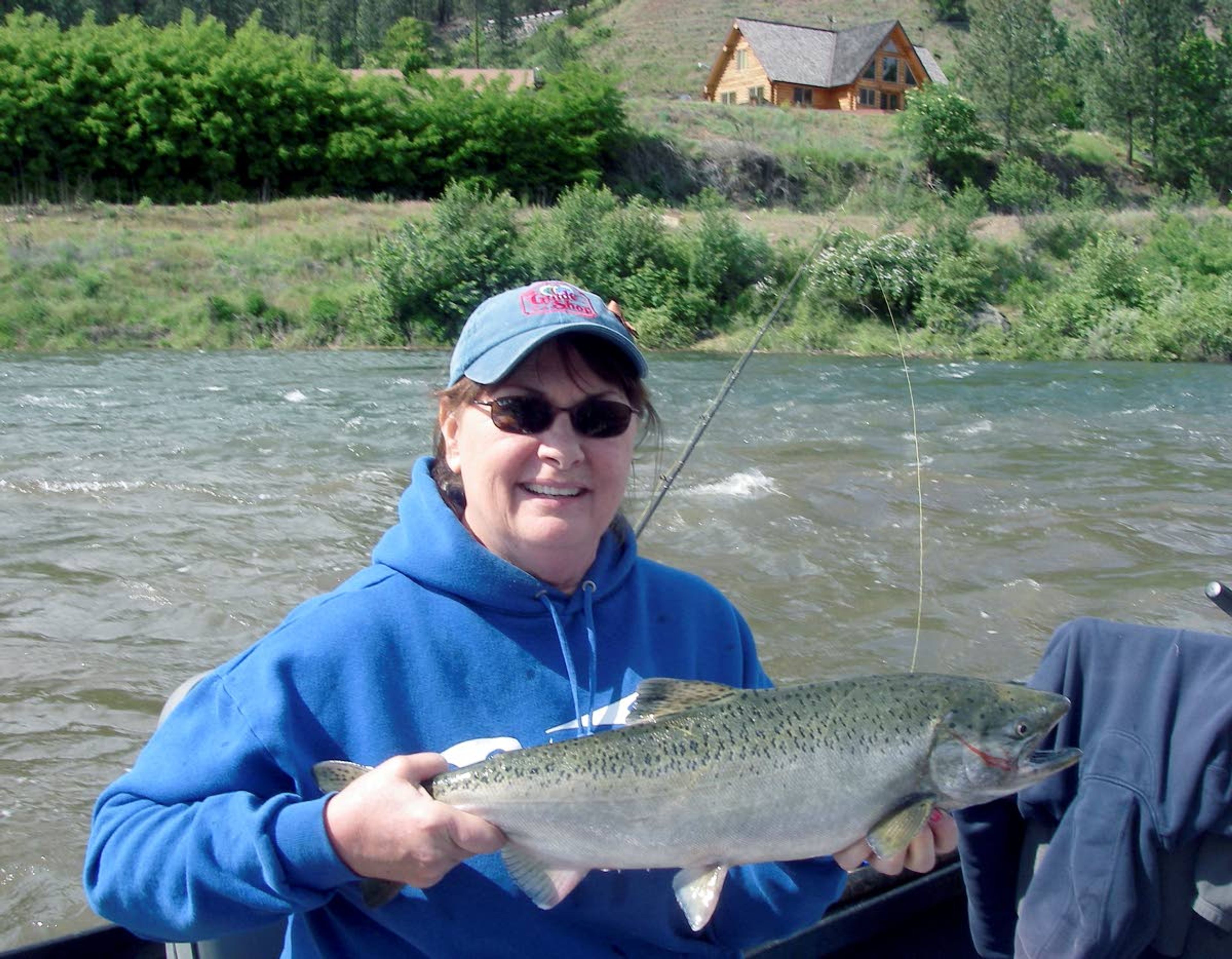 Evelyn Kaide, who’s run The Guide Shop in Orofino, Idaho, for more than 20 years, takes time to land a spring chinook salmon on the Clearwater River.