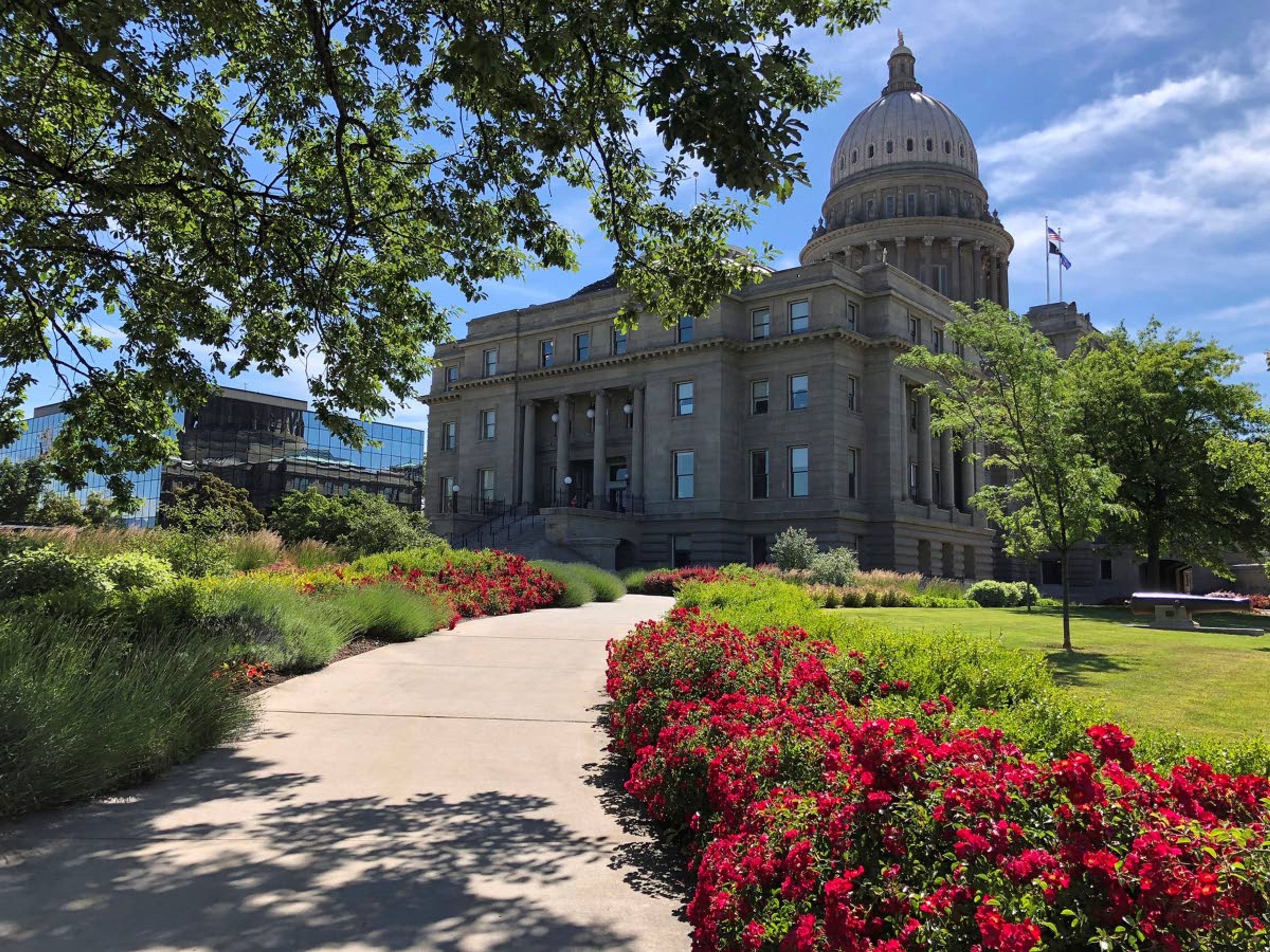 FILE - In this June 13, 2019, file photo, Flowers bloom on a walkway to the Idaho State Capitol in Boise, Idaho. Lawmakers are examining property tax options amid complaints that taxes are going up with rising property values, while also hearing concerns from cities and counties that they're operating on tight budgets. The Property Tax Working Group took no action Monday, Oct. 21, 2019, following a day of presentations that also included university and state financial experts. (AP Photo/Keith Ridler)