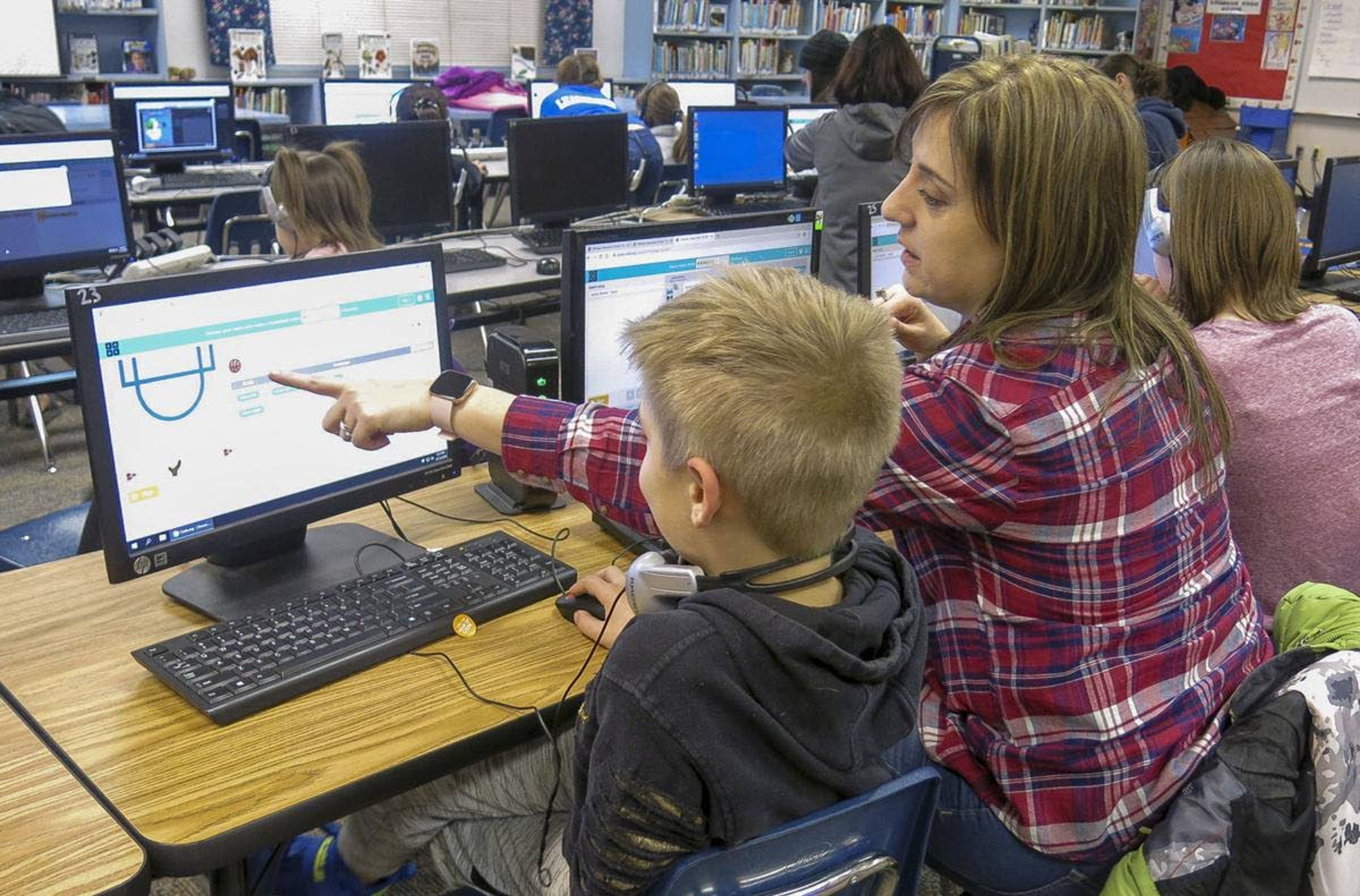 Raina Goodwin helps her son, Javin, 9, code a computer game Thursday during an Hour of Code event at Whitney Elementary School in Yakima.