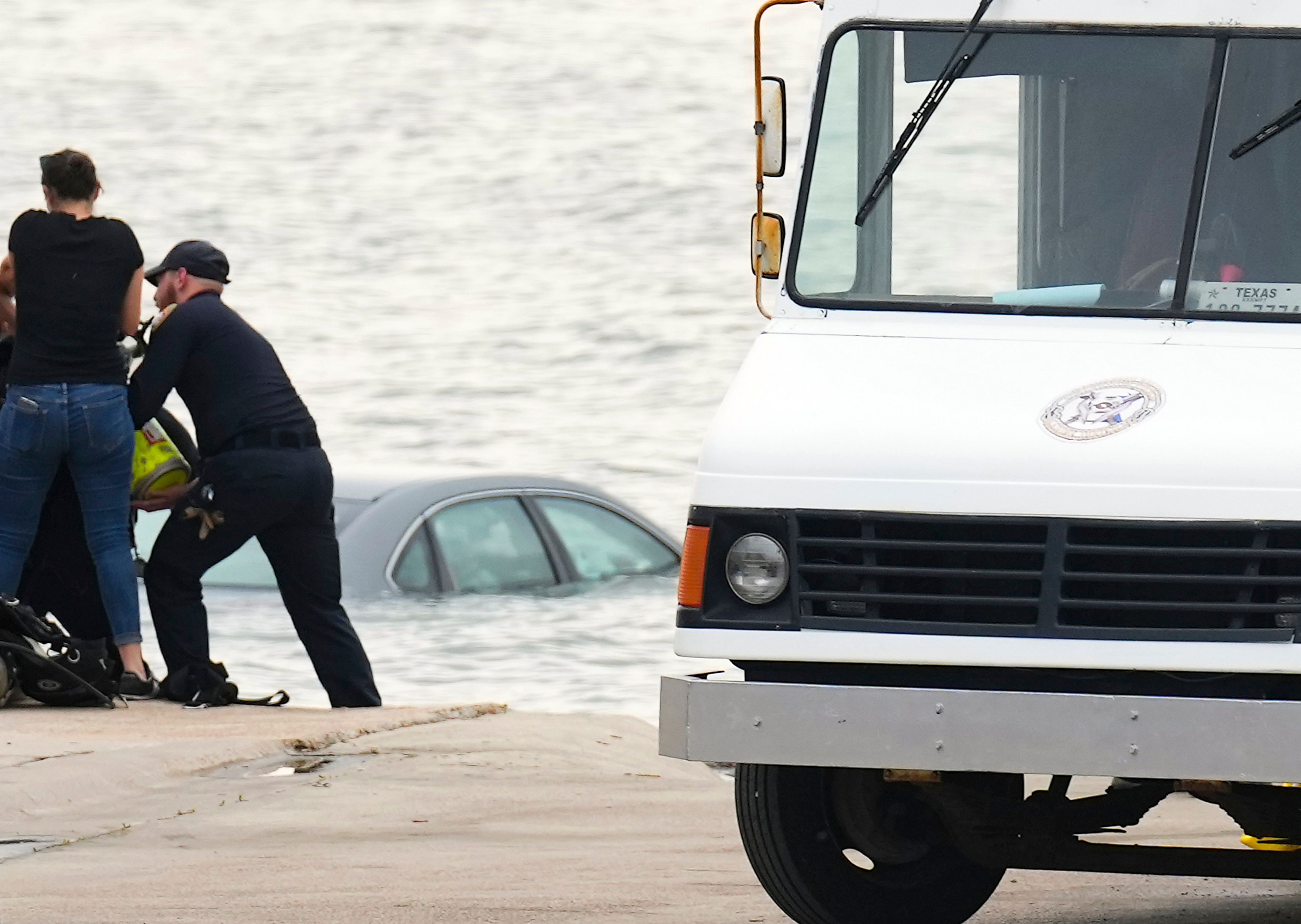 Galveston Police assist in getting a car out of the Galveston Ship Channel, Tuesday, Sept. 3, 2024, in Galveston, Texas, following a fatal shooting of a Texas deputy constable in Houston. A suspect led authorities on a 60 miles chase that ended in the waters off Galveston, where the man tried swimming away to evade arrest before being captured with the help of a marine unit, according to the Port of Galveston Police Department.