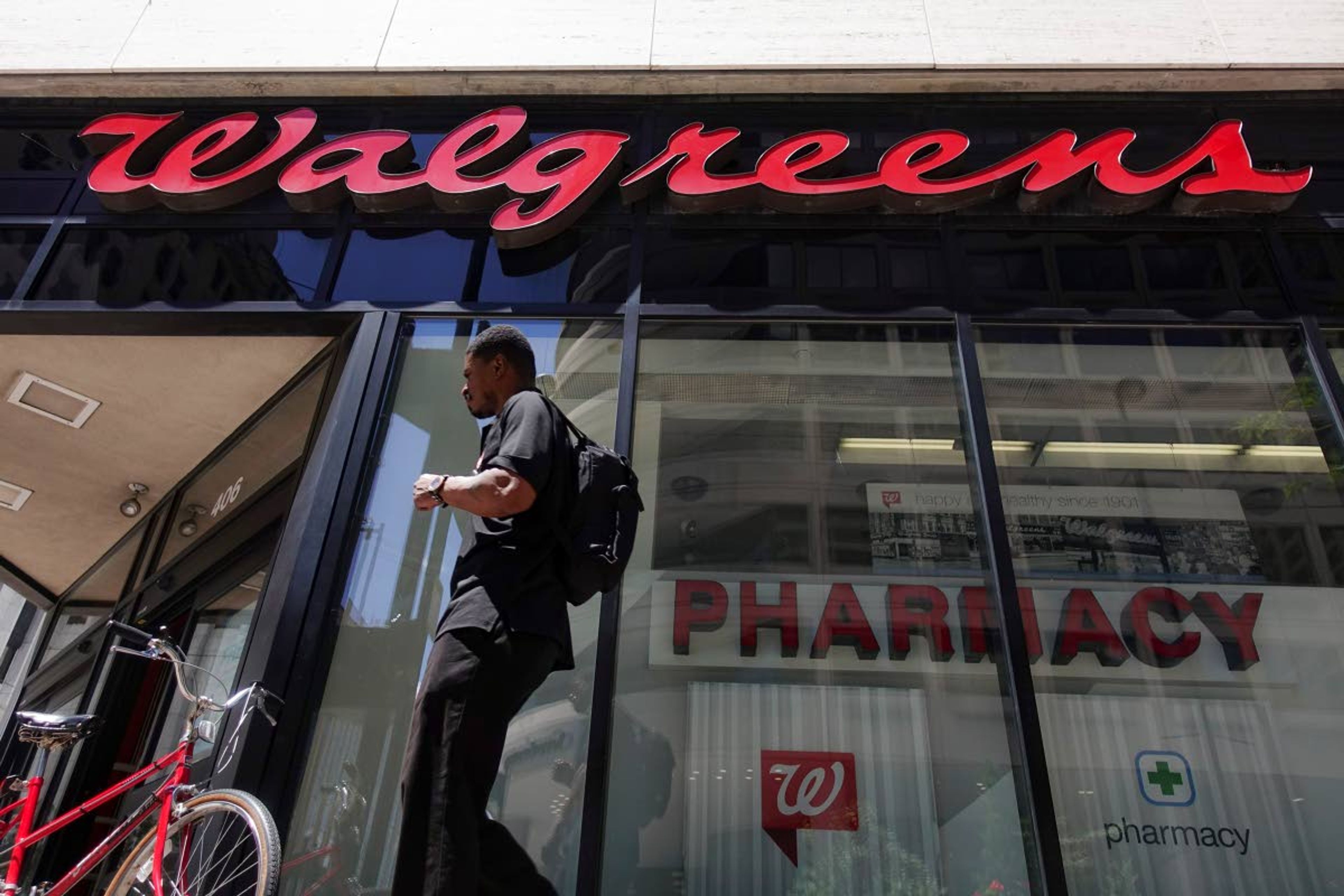 ABOVE: A person walks by a Walgreens pharmacy in downtown Cincinnati in 2016. RIGHT: A CVS pharmacy is shown in August in Jackson, Miss.