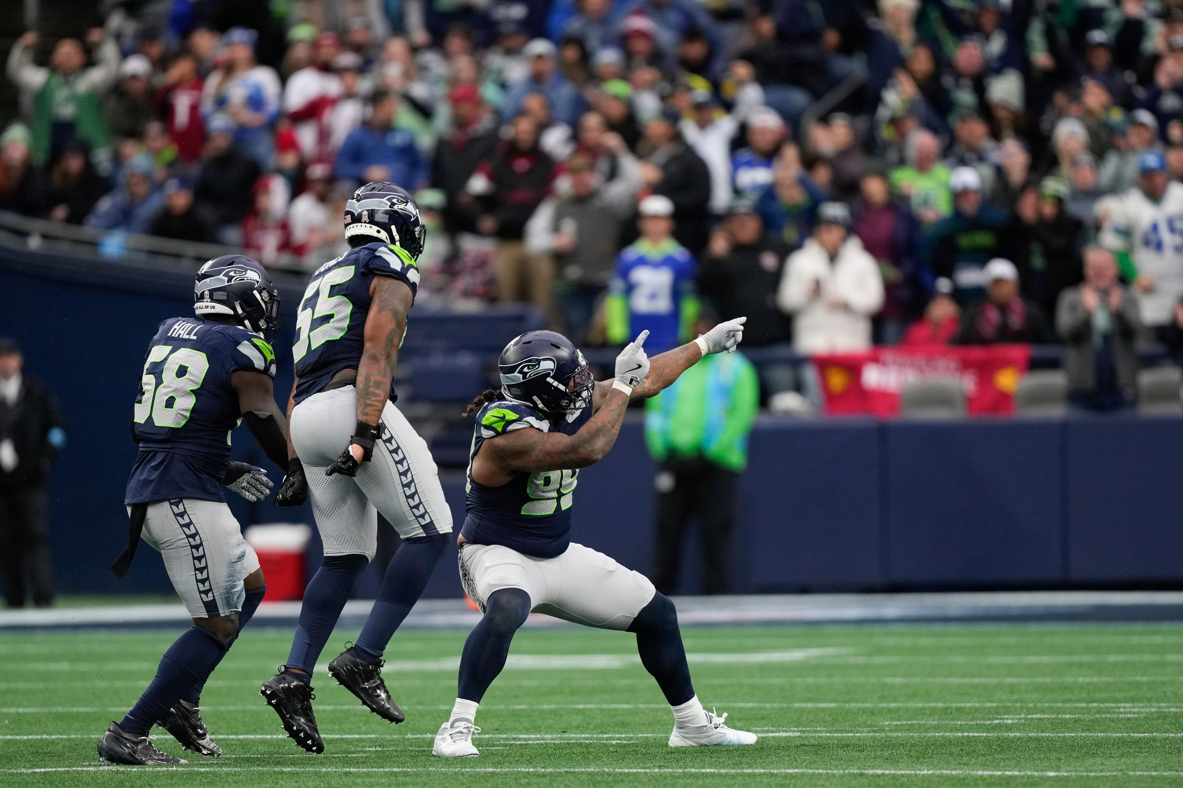 Seattle Seahawks defensive end Leonard Williams (99) celebrates a sack with Dre'Mont Jones (55) and linebacker Derick Hall (58) during the second half of an NFL football game against the Arizona Cardinals, Sunday, Nov. 24, 2024, in Seattle. (AP Photo/Stephen Brashear)