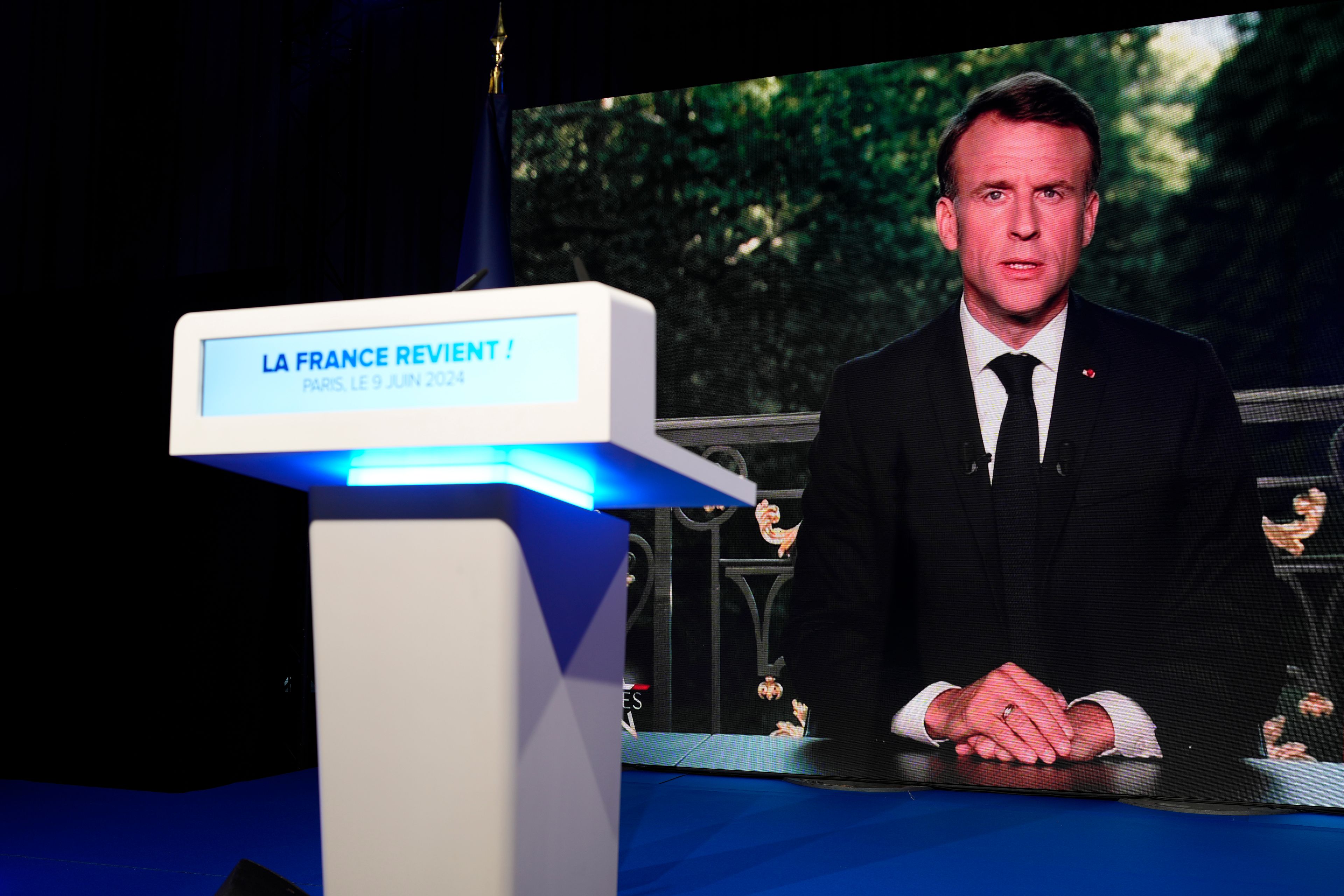 French President Emmanuel Macron appears on television screen at the French far-right National Rally party election night headquarters, Sunday, June 9, 2024 in Paris. French President Emanuel Macron dissolves National Assembly and calls new legislative election after defeat in EU vote