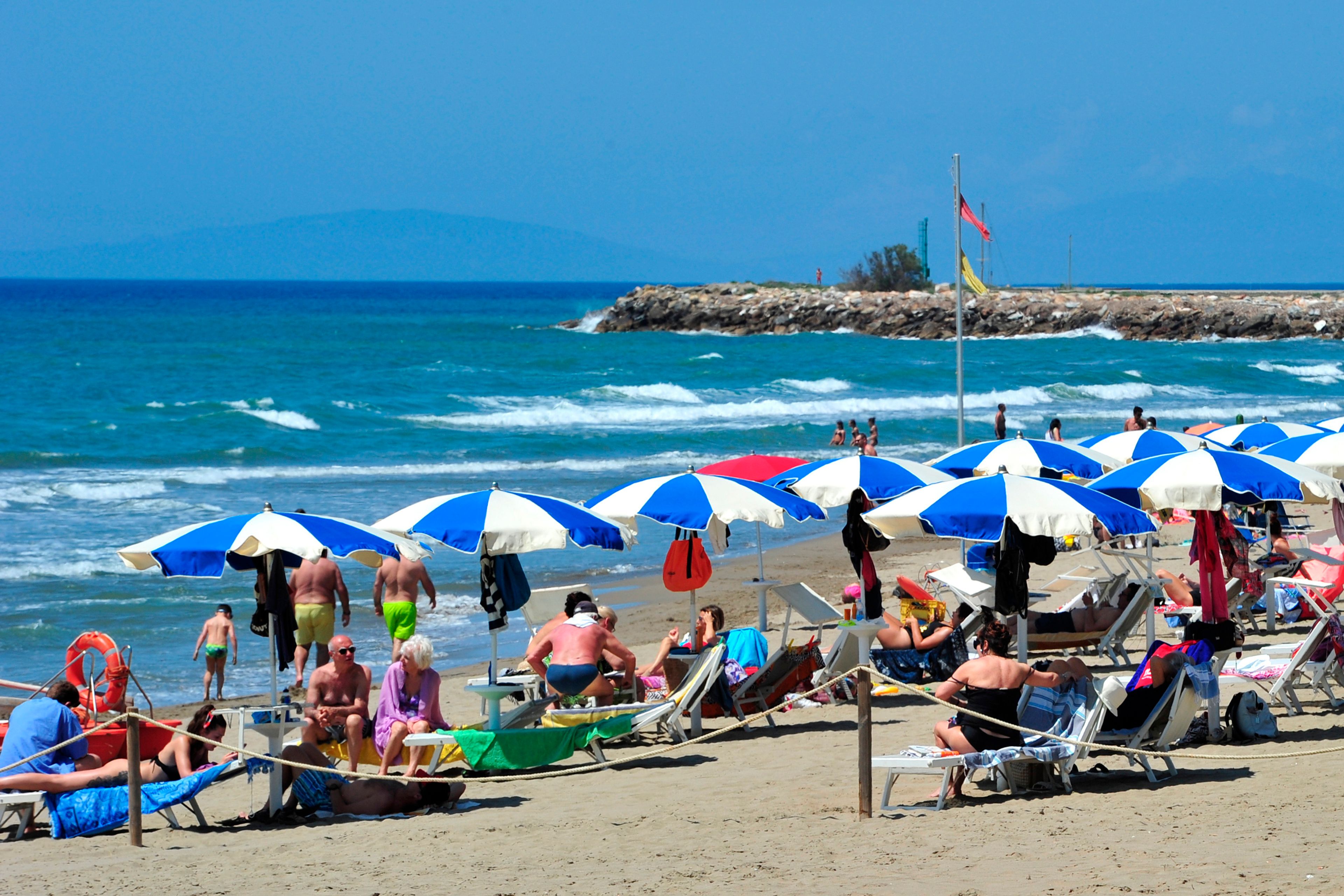 FILE - People enjoy a sunny day at an establishment on the beach in Tuscany's Castiglione della Pescaia, Italy, Sunday, May 24, 2020.