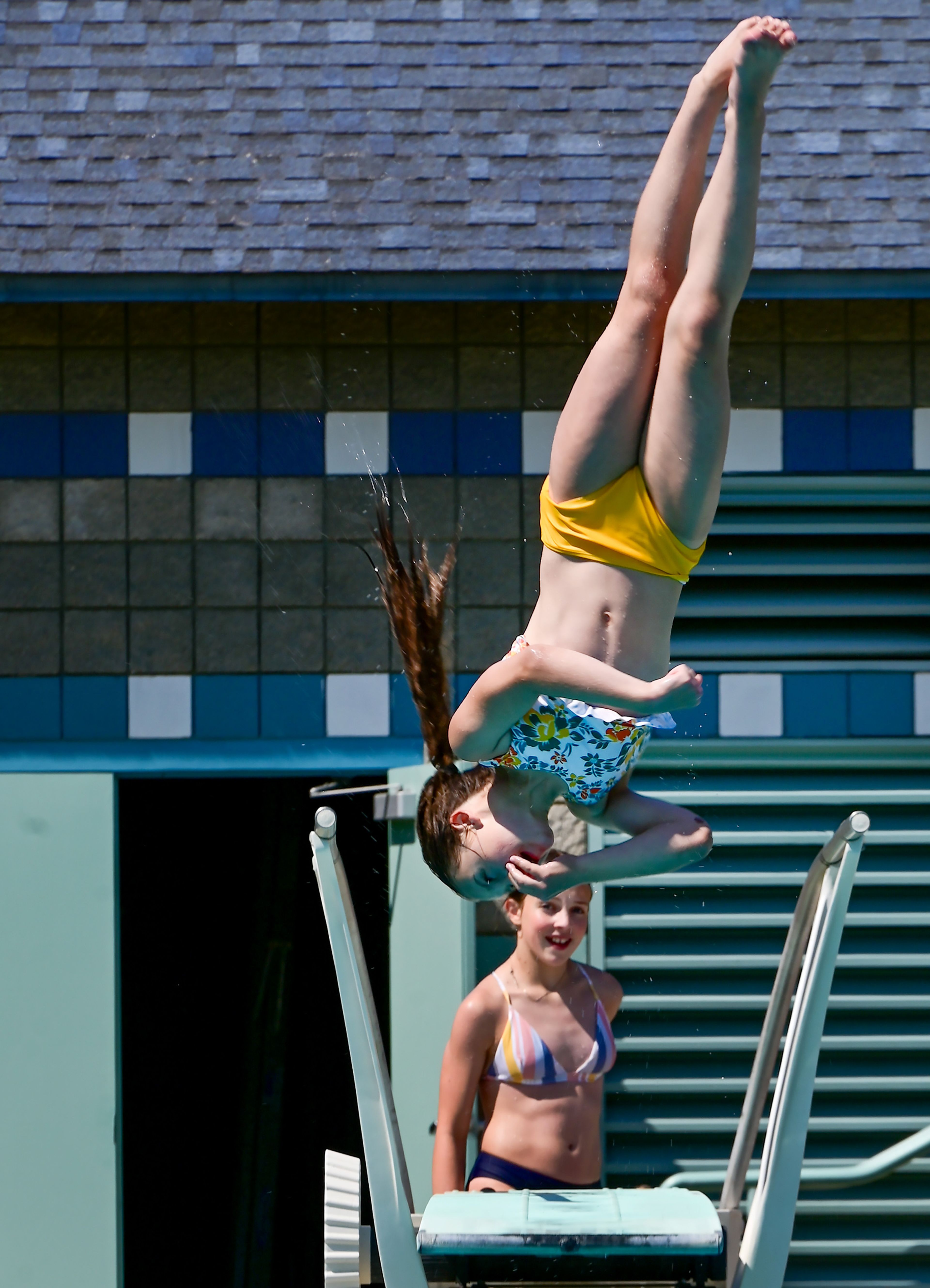 Whitney Gravel, 12, of Pullman, flips off the diving board at the Hamilton-Lowe Aquatics Center on Monday in Moscow. The pool was busy as temperatures reach the 90s.