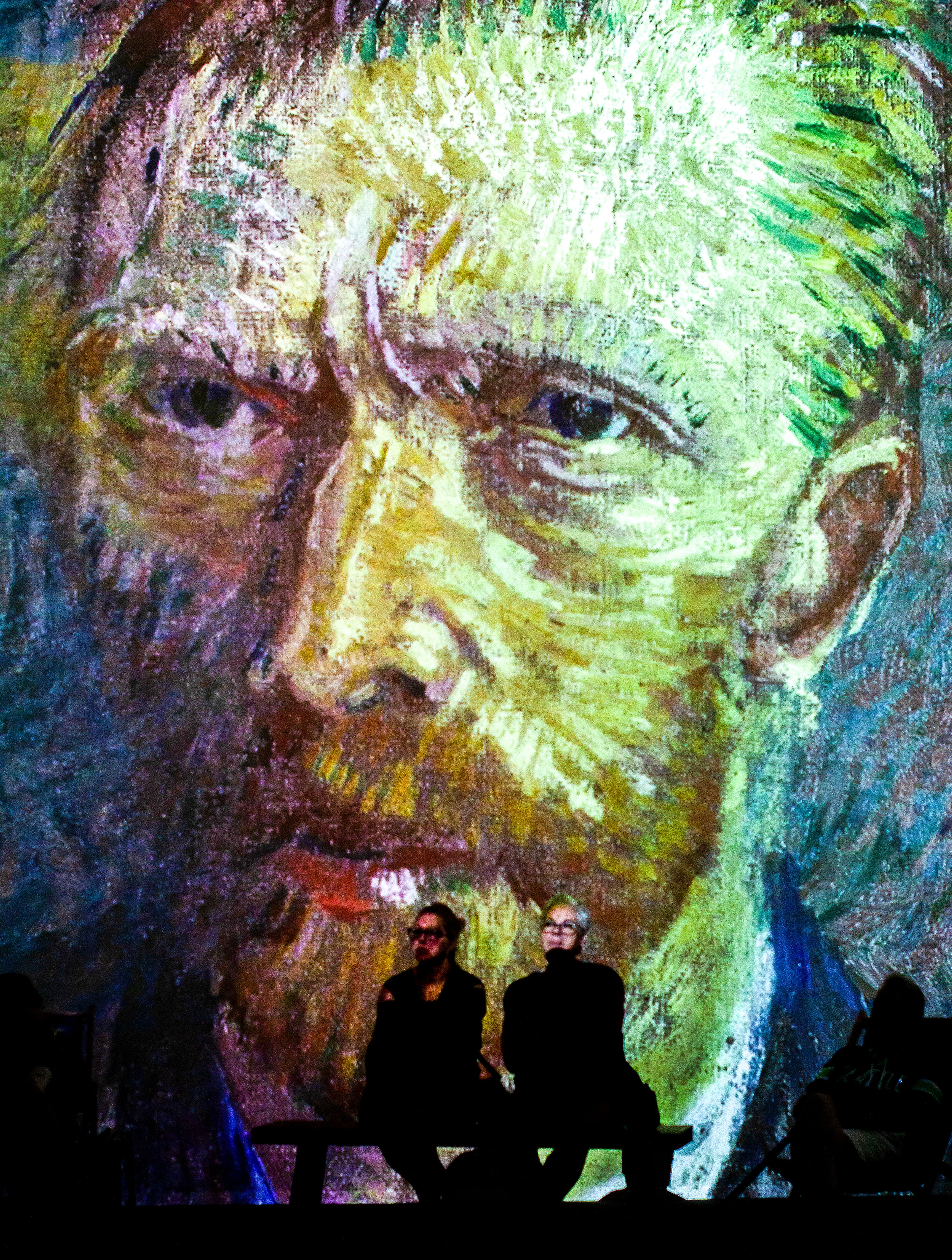 Visitors sit in an immersive gallery viewing floor-to-ceiling projections of Vincent Van Gogh's artwork at the exhibit on July 29 in Spokane.