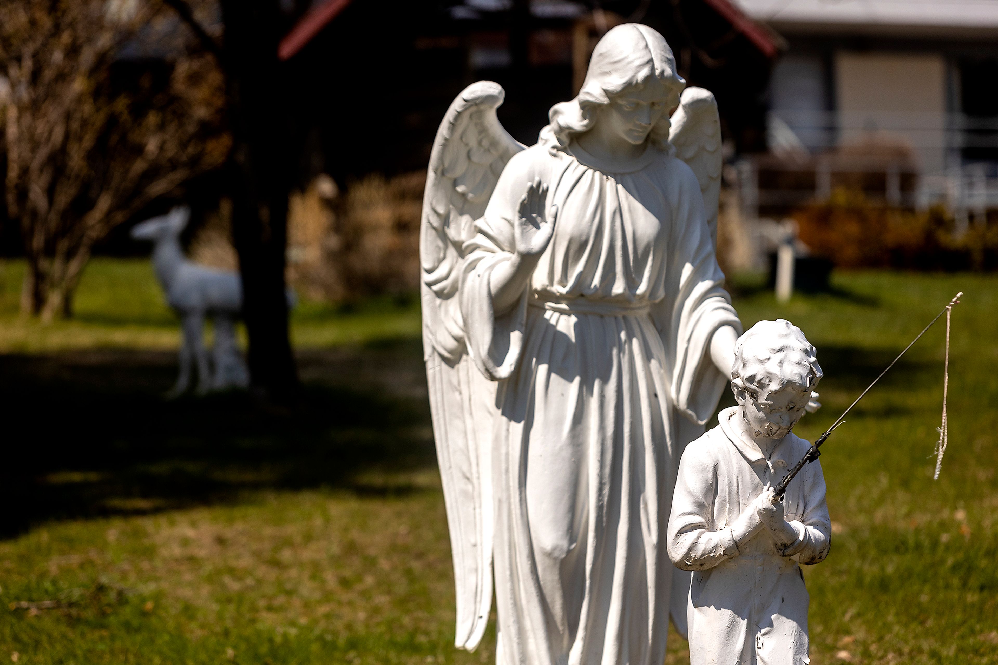 An angel keeps watch over a fishing boy as a deer stands in the background in statue form at the St. Gertrude Monastery in Cottonwood.