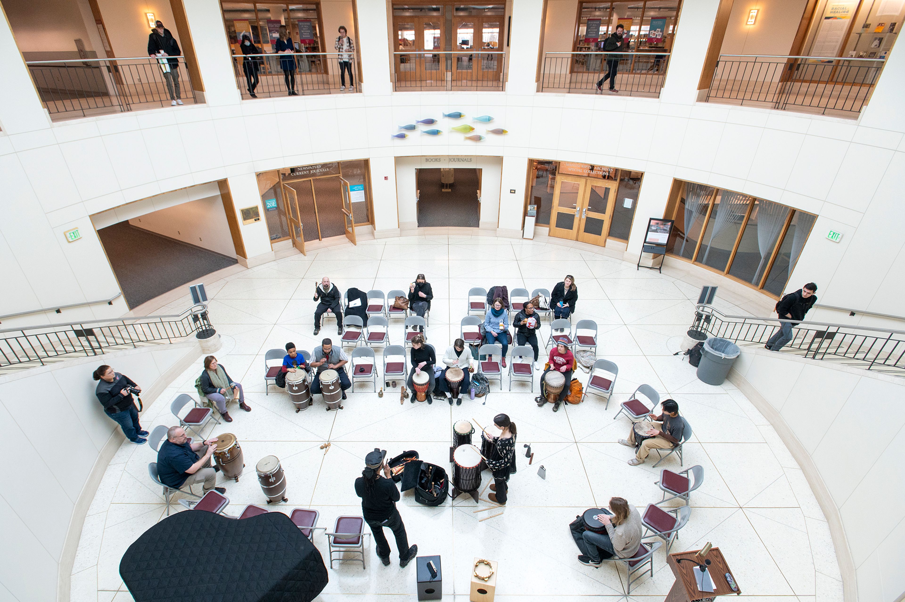 Visitors gather to listen and participate in a drum circle Tuesday at Washington State University’s Terrell Library Atrium in Pullman for the National Day of Racial Healing.