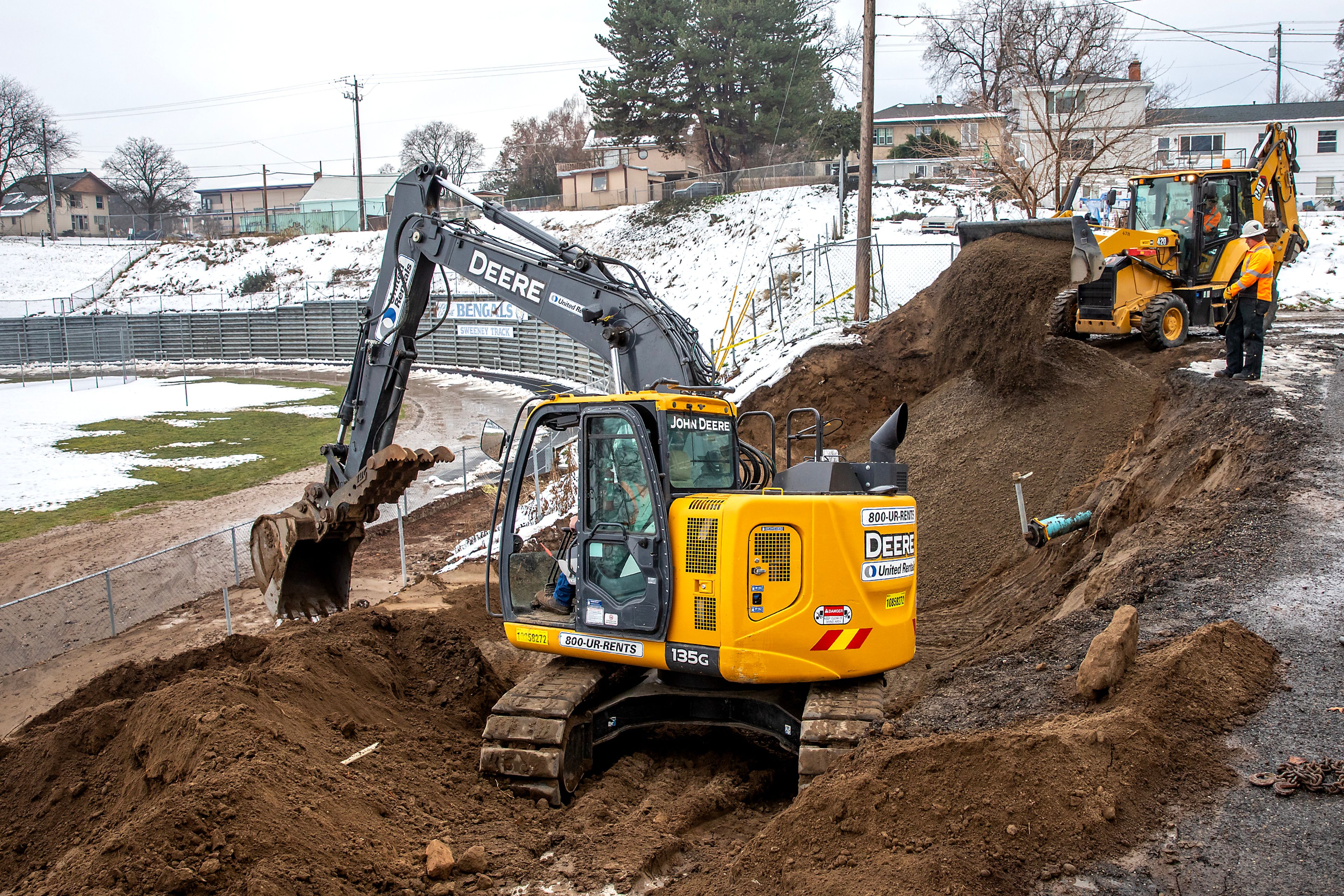 Workers fill in a sinkhole on the west side of the Vollmer Bowl on Monday in Lewiston. The sinkhole was caused by a broken water line Saturday, and resulted in Sweeney Track being inundated with water and debris.