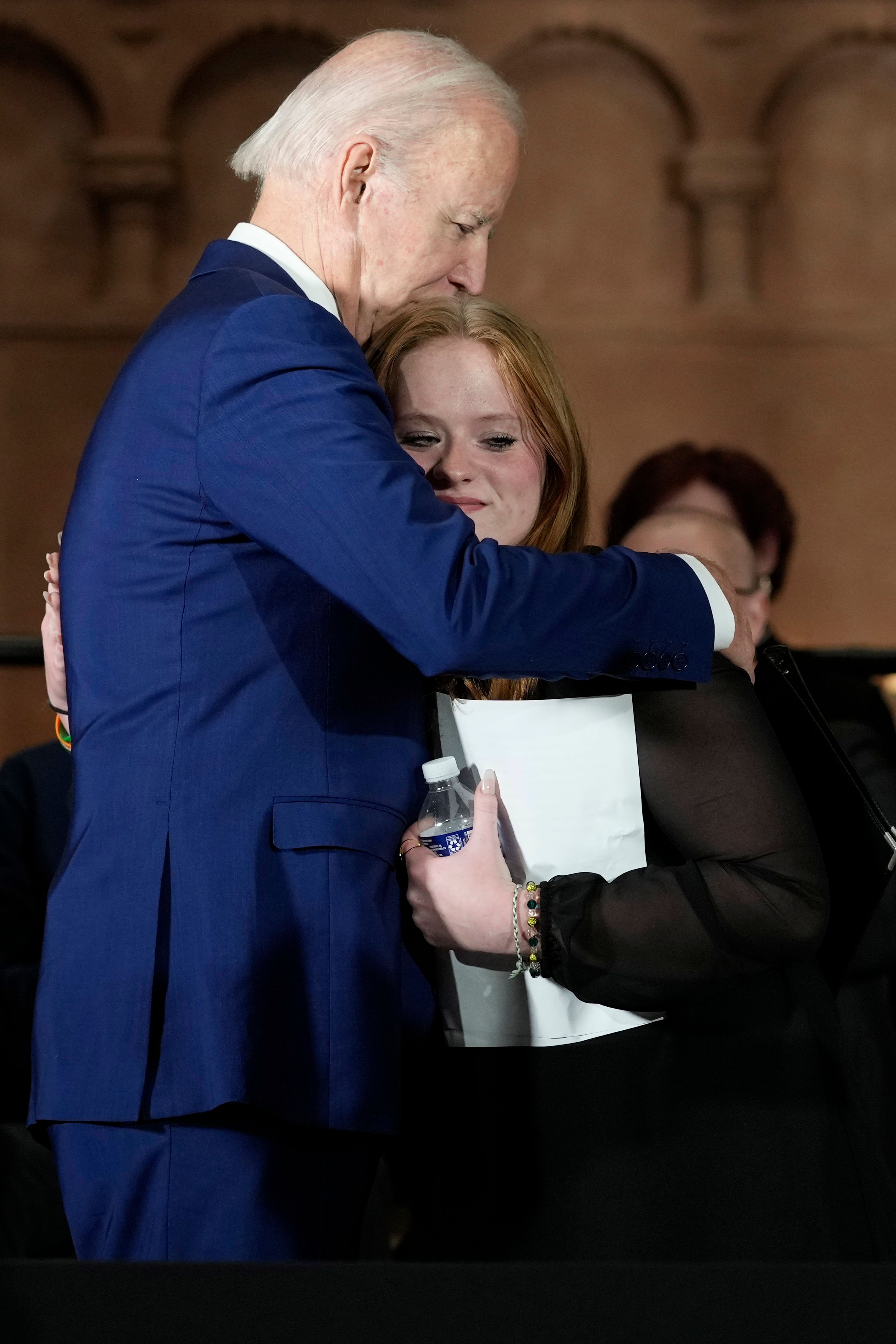 President Joe Biden hugs Sandy Hook survivor Jackie Hegarty, who introduced him, during an event in Washington, Wednesday, Dec. 7, 2022, with survivors and families impacted by gun violence for the 10th Annual National Vigil for All Victims of Gun Violence. (AP Photo/Susan Walsh)