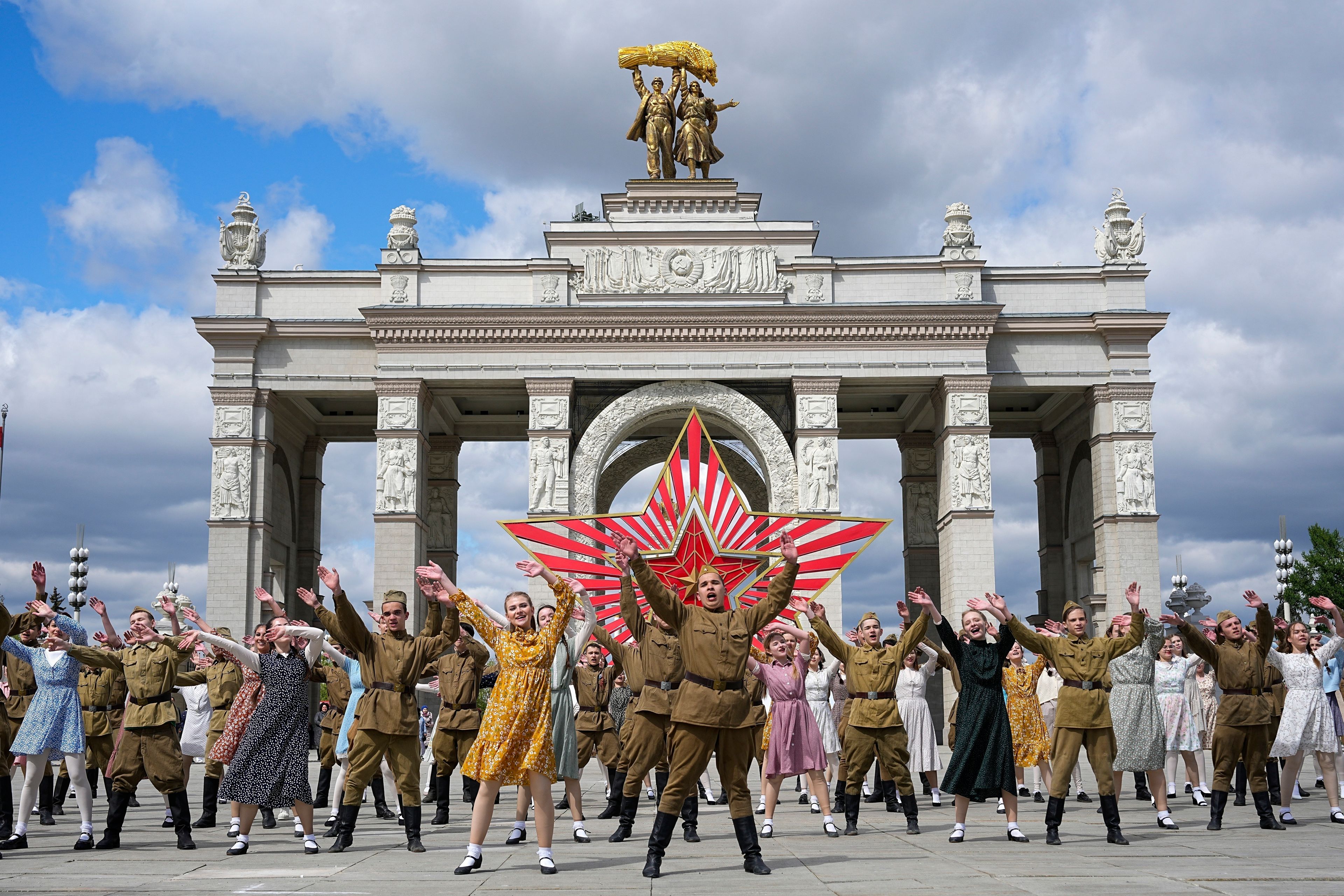 FILE - Moscow students dressed in the fashion of the middle of the last century and Soviet style uniform perform "Victory Waltz" as a part of Victory Day celebration in front of the historical main gates of VDNKh, The Exhibition of Achievements of National Economy, with the red star in the background in Moscow, Russia, Saturday, May 6, 2023. In Russia, history has long become a propaganda tool used to advance the Kremlin's political goals. In an effort to rally people around the flag, the authorities have sought to magnify the country's past victories while glossing over the more sordid chapters of its history. (AP Photo, File)