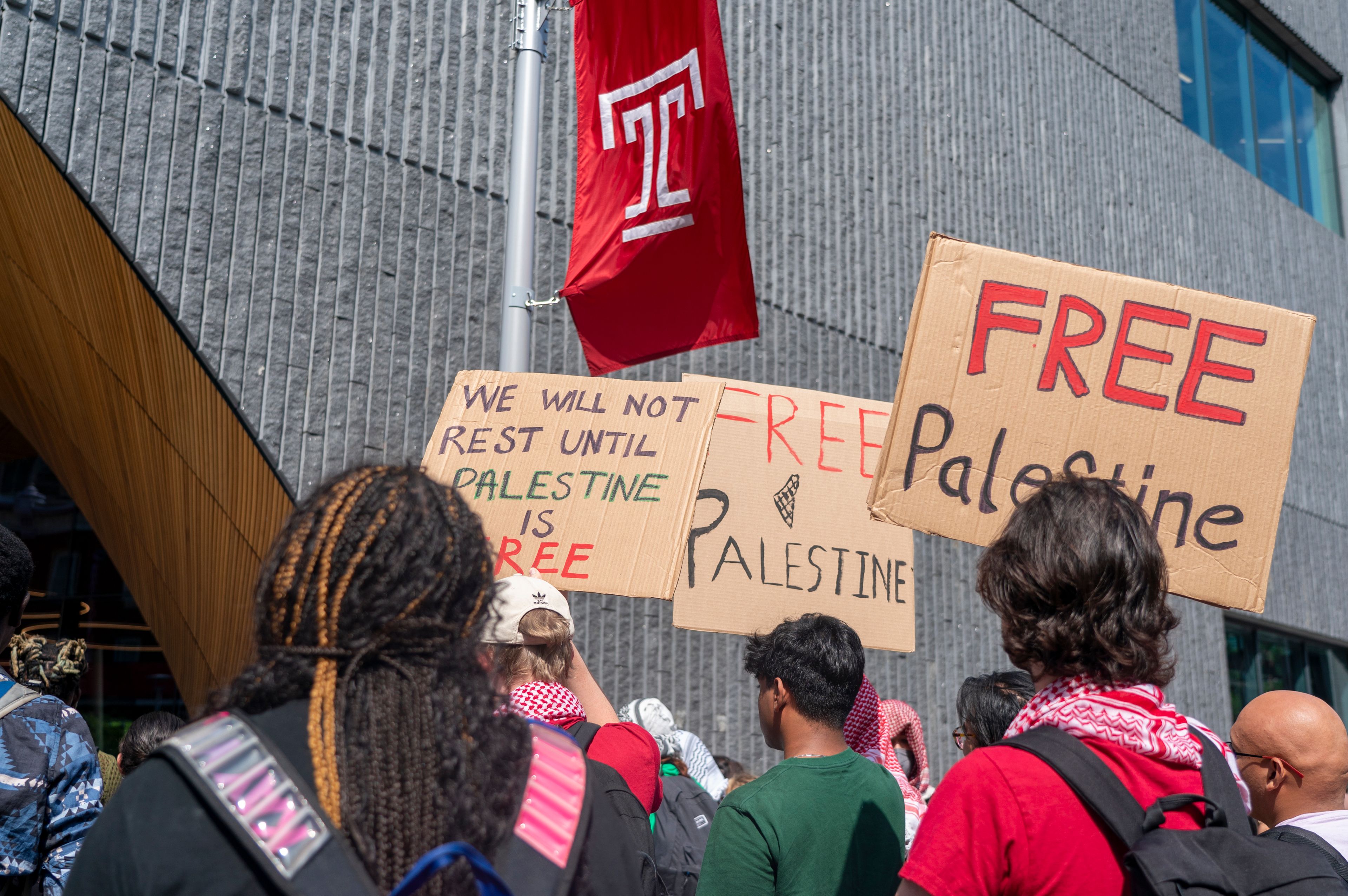 People hold up signs during a pro-Palestine rally and march on Temple University campus in Philadelphia, Aug. 29, 2024.