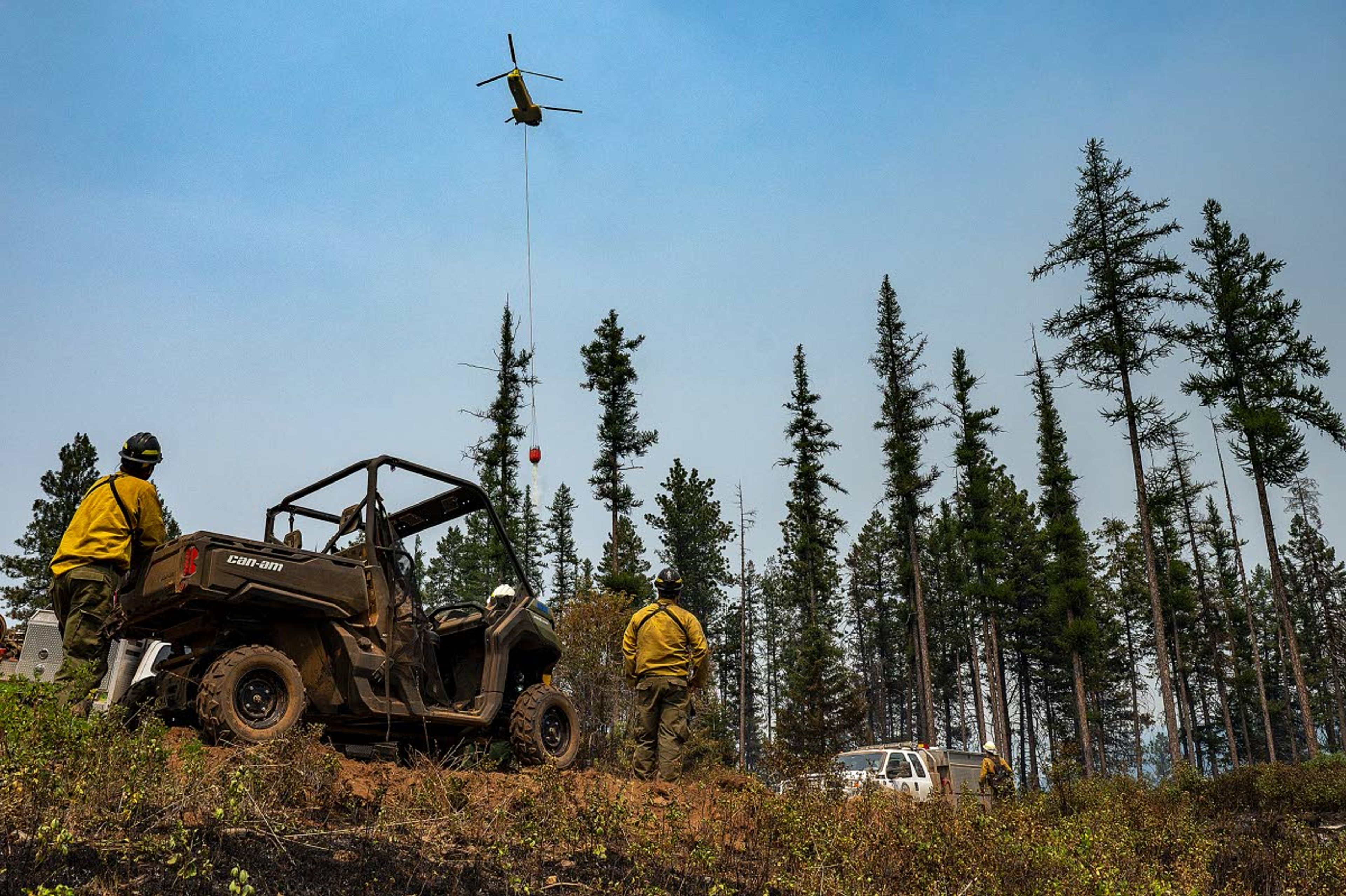 A crew of wildland firefighters watch as a helicopter drops water on hot spots along Captain John Ridge on Thursday afternoon at the Snake River Complex fire south of Lewiston. The complex now covers more than 100,000 acres.