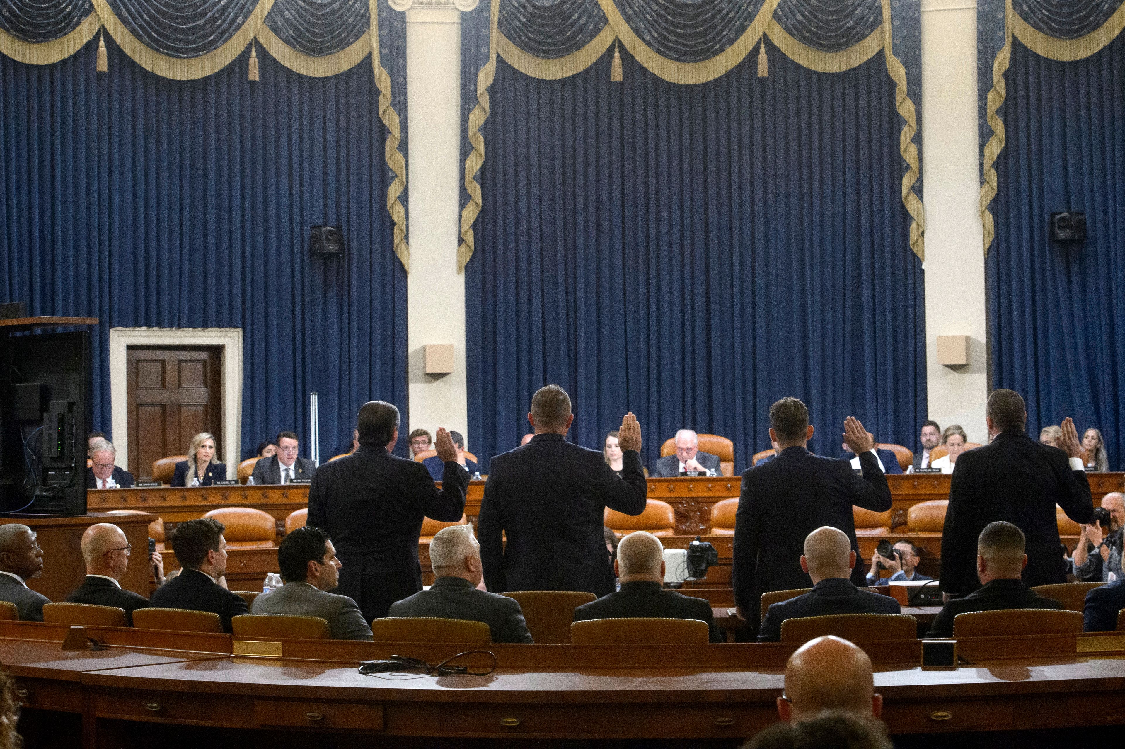 Witnesses stand to be sworn-in from left, Dr. Ariel Goldschmidt, Medical Examiner of Allegheny County, Pa. (appearing virtually), Patrick Sullivan, former U.S. Secret Service agent, Lt. John D. Herold of Pennsylvania State Police, Patrolman Drew Blasko of Butler Township Police Dept. , and Sgt. Edward Lenz of Adams Township Police Department and Commander of the Butler County Emergency Services Unit, during a House Task Force hearing on the July 13, 2024 attempted assassination of Republican presidential nominee former President Donald Trump in Butler, Pa., Thursday, Sept. 26, 2024, on Capitol Hill, in Washington. (AP Photo/Rod Lamkey, Jr.)