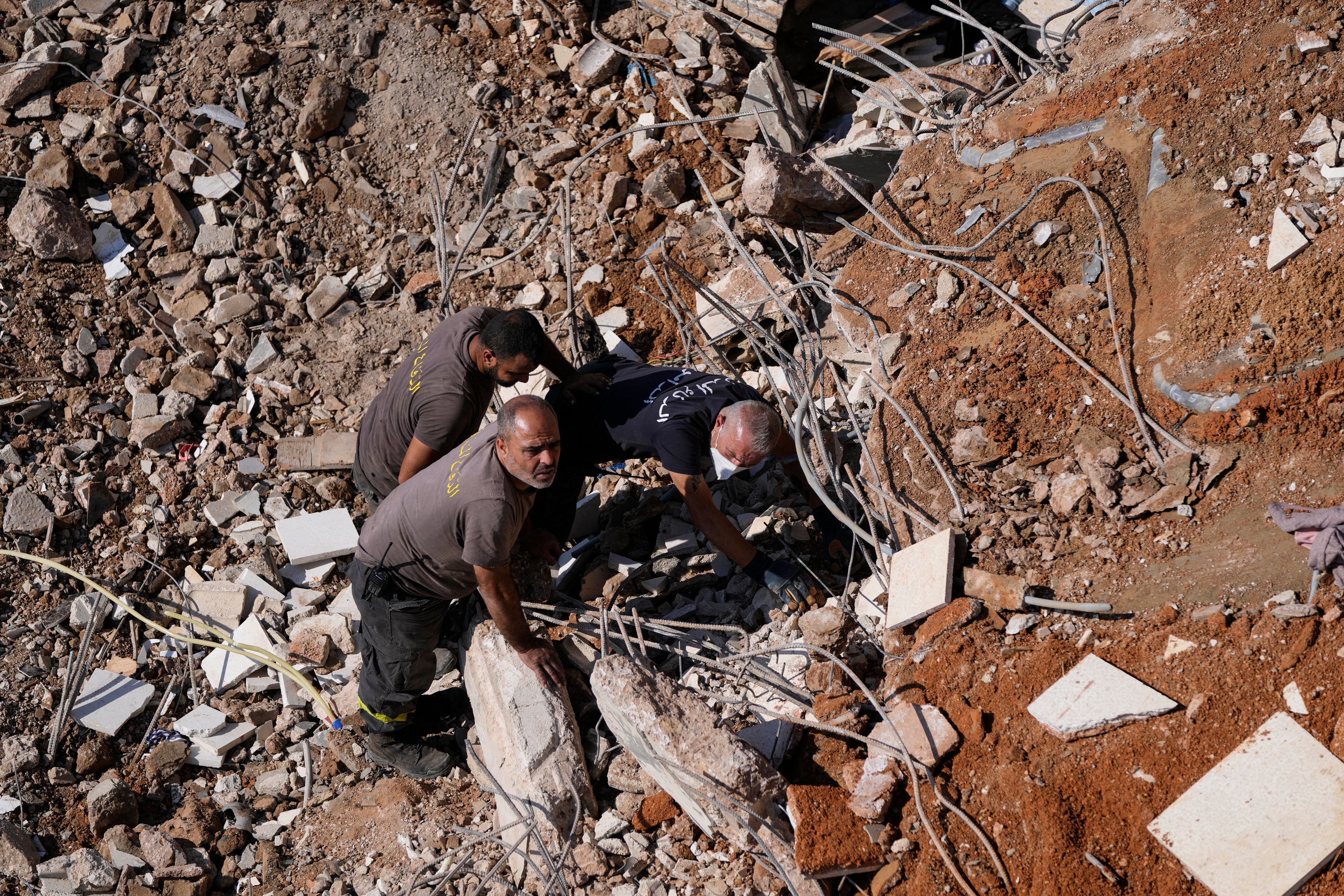 Civil defense workers search for victims in the rubble of a destroyed building hit in an Israeli airstrike on Tuesday night, in Barja, Lebanon, Wednesday, Nov. 6, 2024. (AP Photo/Hassan Ammar)