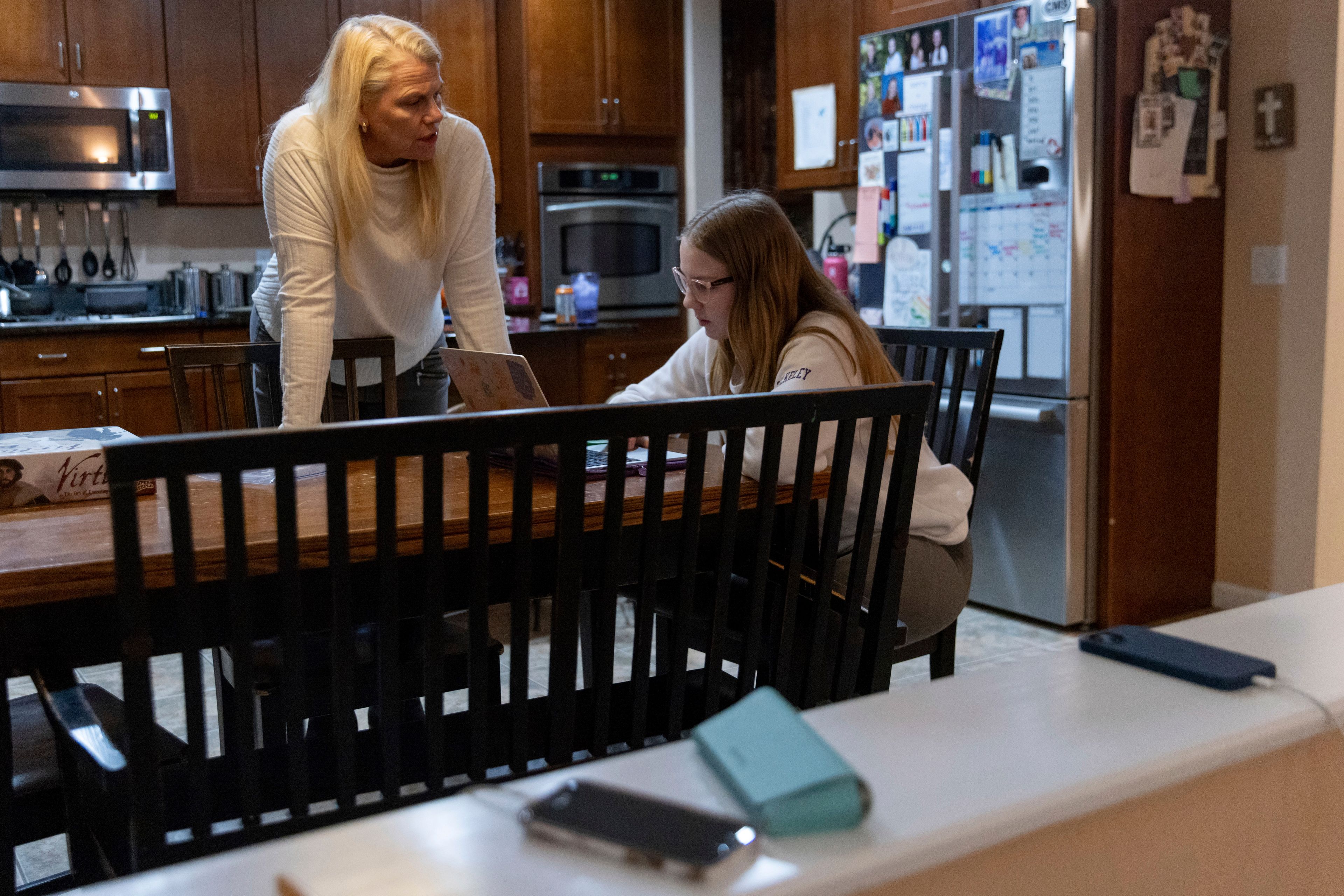 Cell phones charge on a ledge between the living room and kitchen as Steph Bulkeley helps Kate select school courses, Friday, Feb. 16, 2024, in Westport, Conn. With the damaging consequences of social media increasingly well documented, many parents are trying to raise their children with restrictions or blanket bans. Teenagers themselves are aware that too much social media is bad for them, and some are initiating social media “cleanses” because of the toll it takes on mental health and grades.