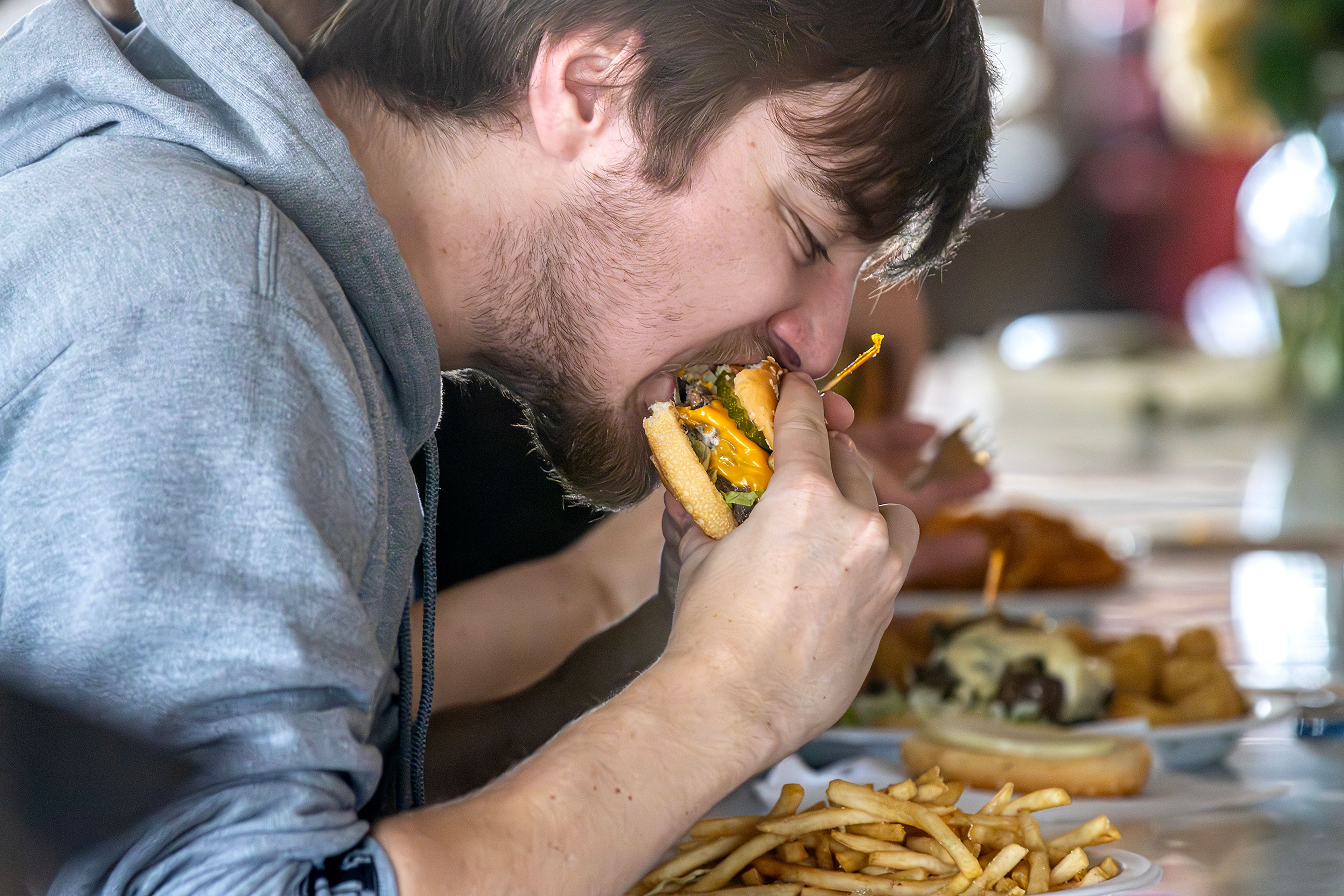 Alex McElroy digs into his burger Thursday at the Keuterville Pub & Grub.