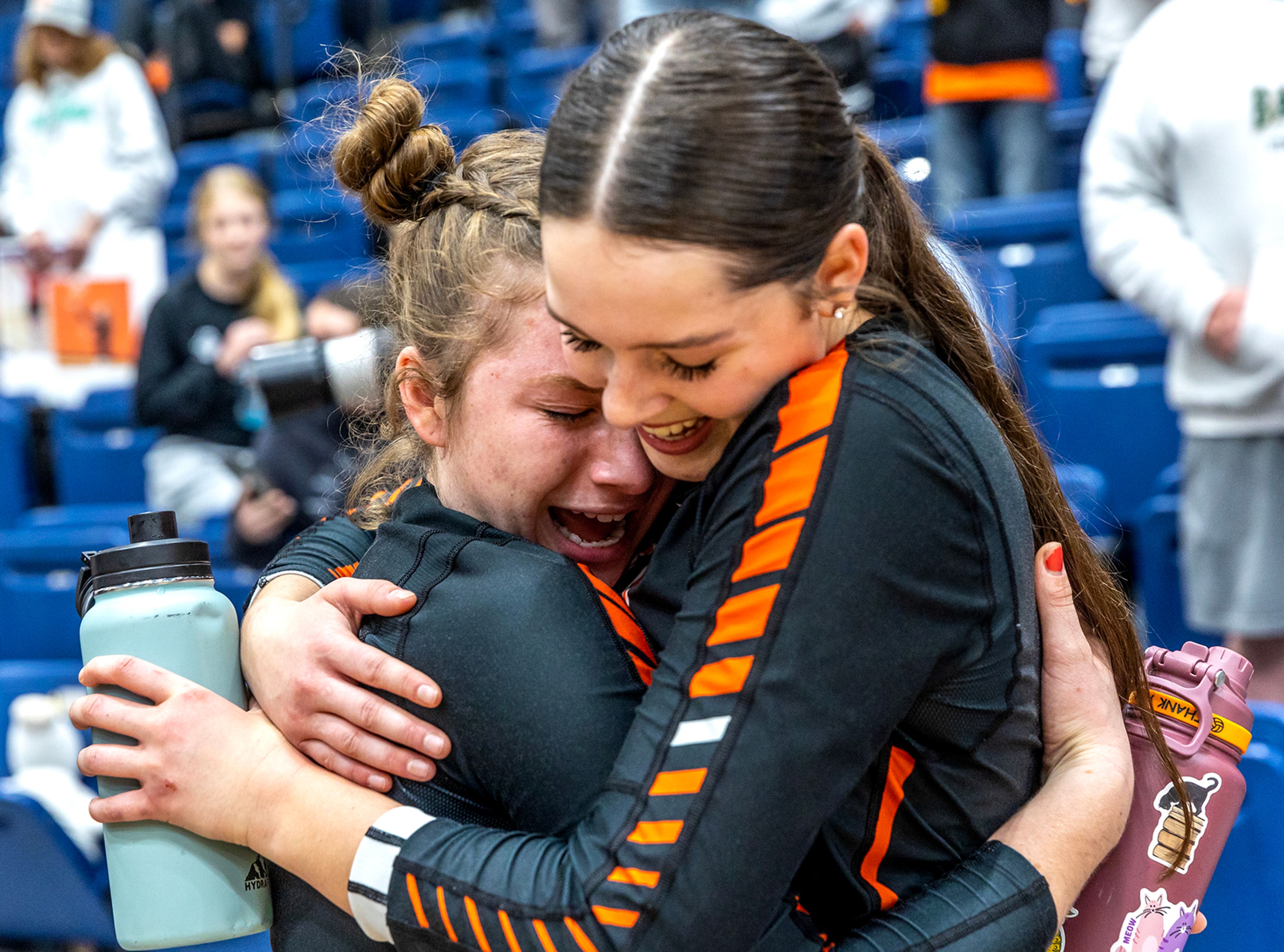 Troy’s Bethan Phillis, left, and Jolee Ecklund, right, embrace after a victory over Grace at the Idaho Class 1A DI volleyball state championship match Oct. 28 at the P1FCU Activity Center in Lewiston.