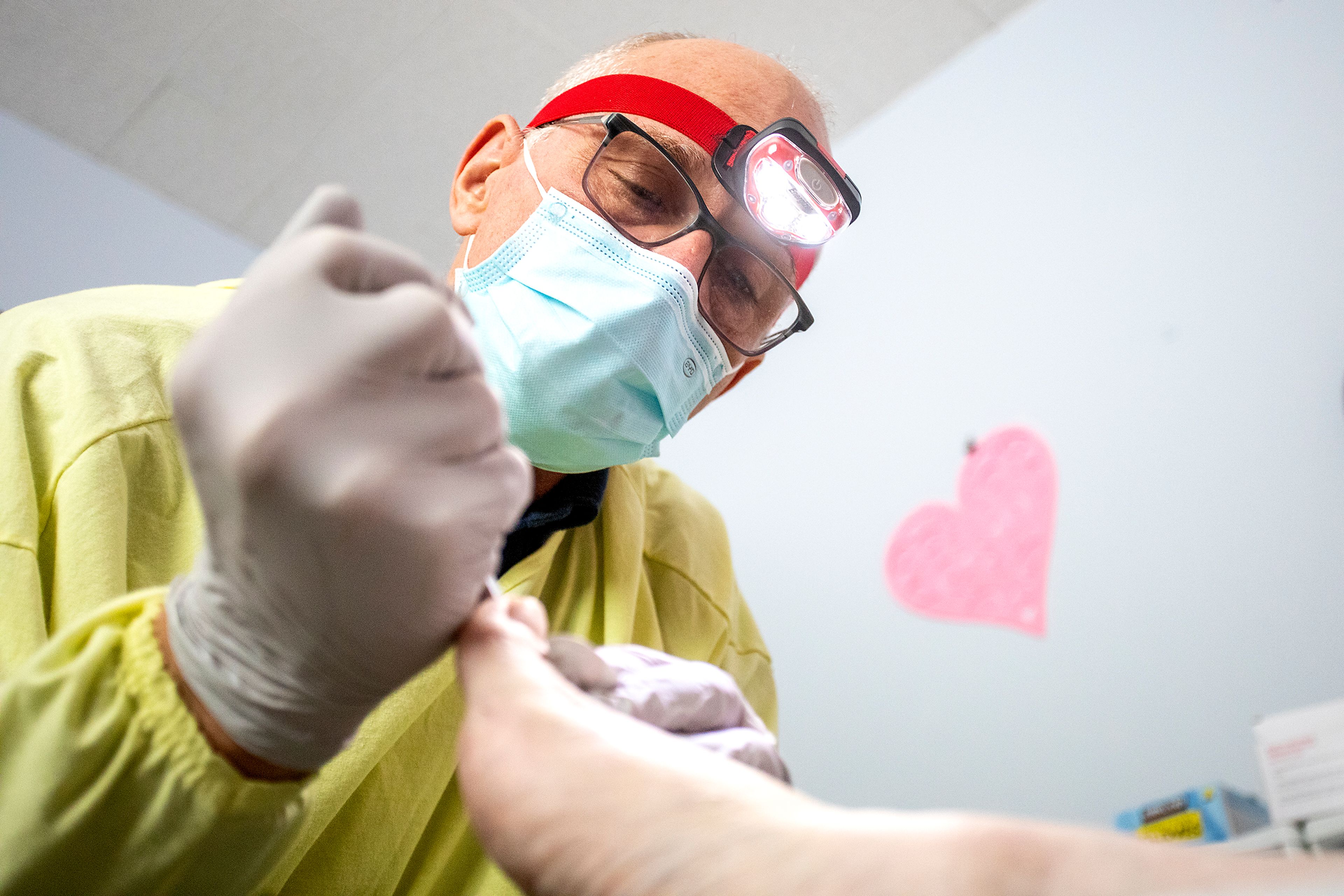 Nurse Aaron Loudenback clips the nails of Mary Lou Gregory during an examination in February.