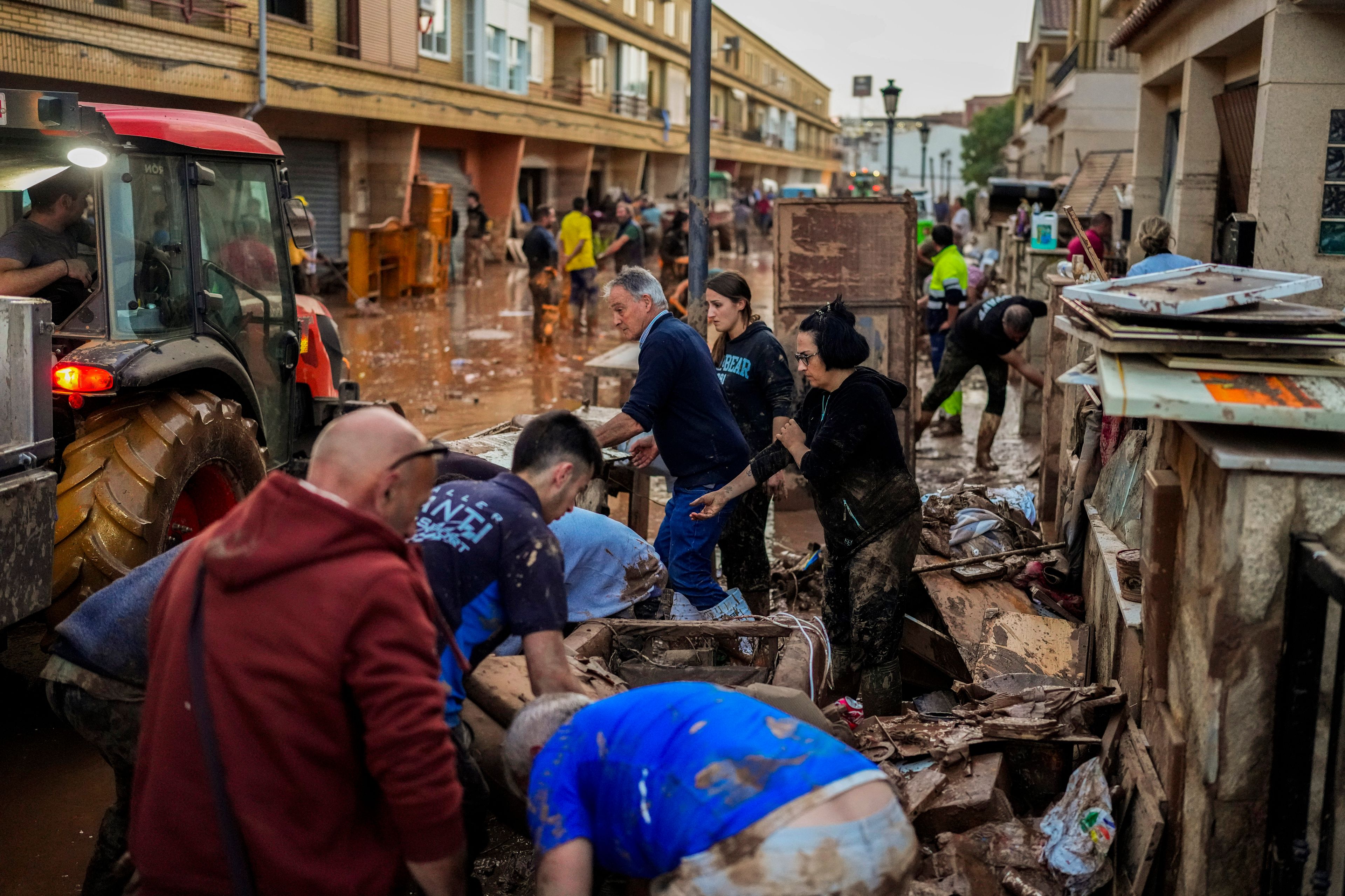 People clean their houses affected by floods in Utiel, Spain, Wednesday, Oct. 30, 2024. (AP Photo/Manu Fernandez)