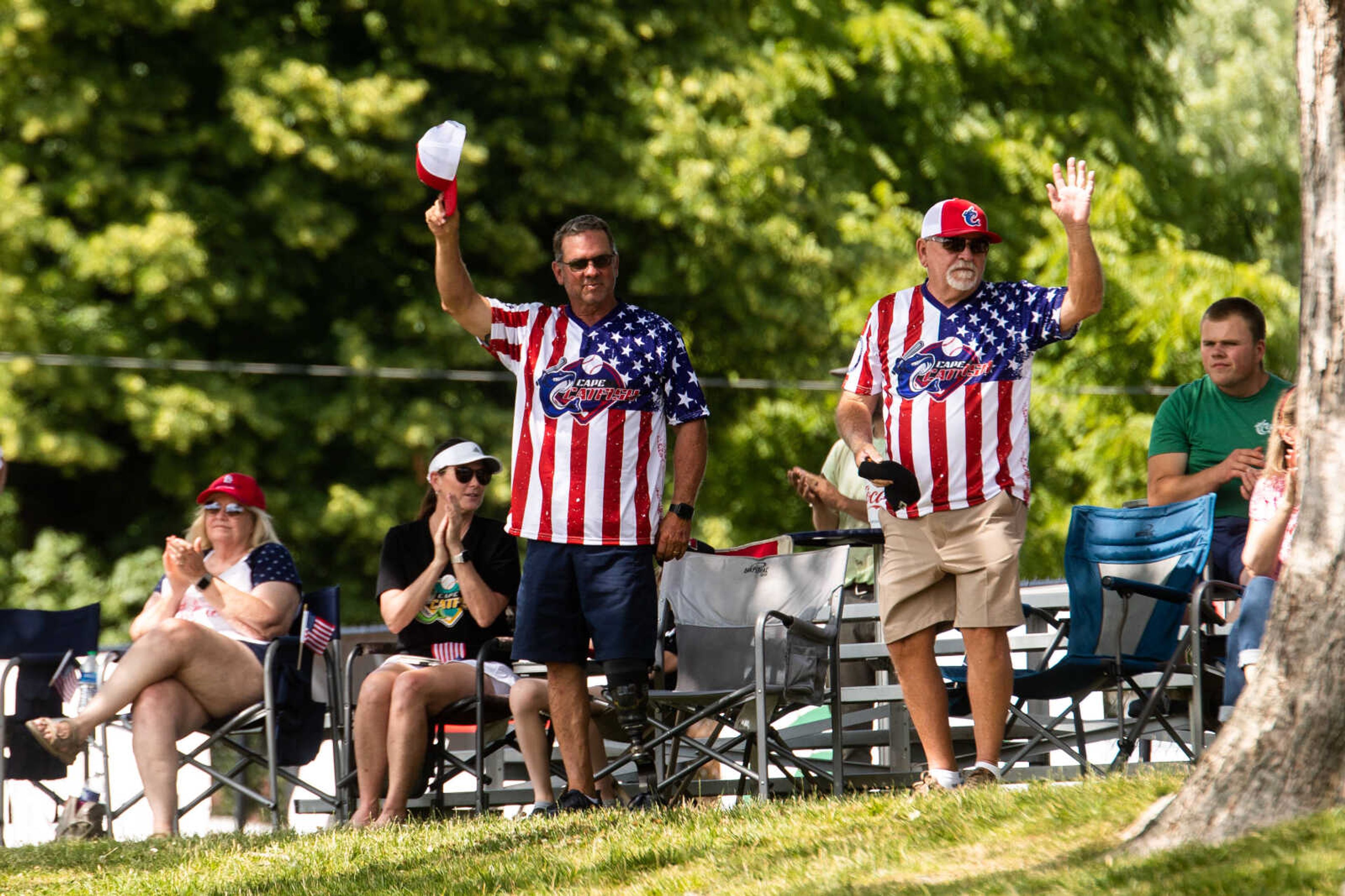 Veterans Dave Cantrell and Ron Seabaugh wave as the stadium claps for vets and service members on Flag Day.