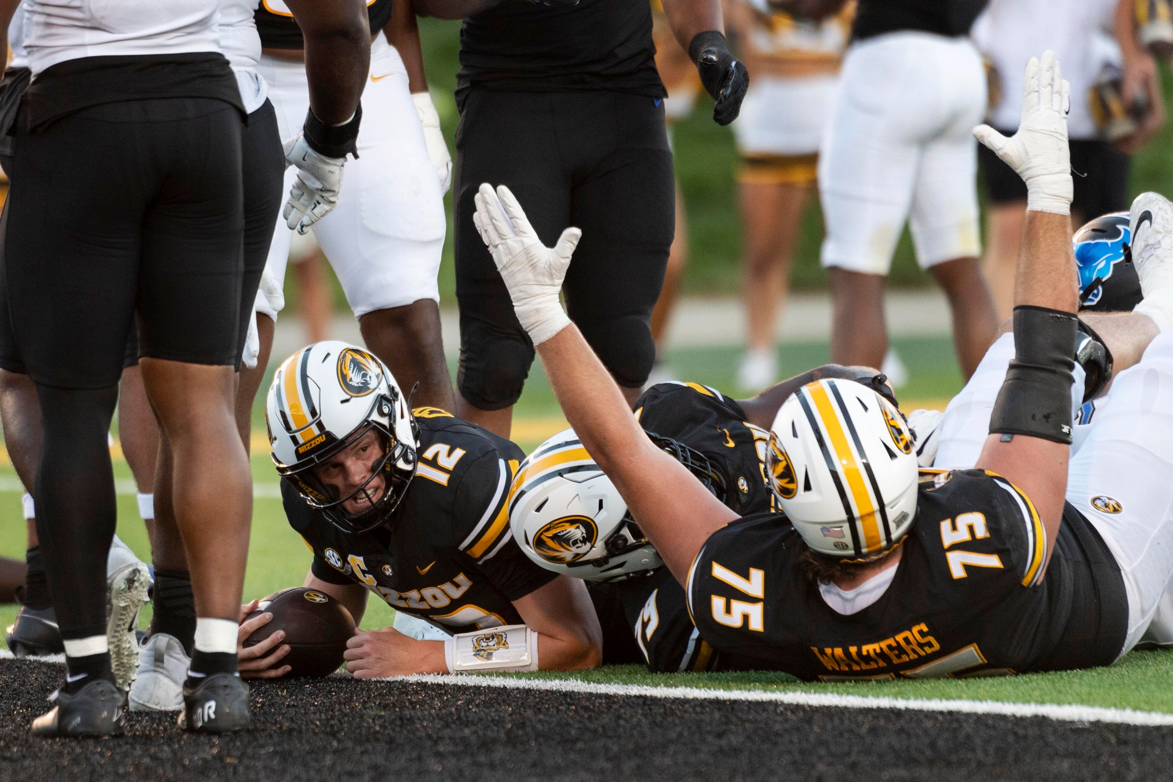 Missouri quarterback Brady Cook (12) looks up after scoring a touchdown as teammate Mitchell Walters (75) celebrates during the first half of an NCAA college football game against Buffalo, Saturday, Sept. 7, 2024, in Columbia, Mo. (AP Photo/L.G. Patterson)