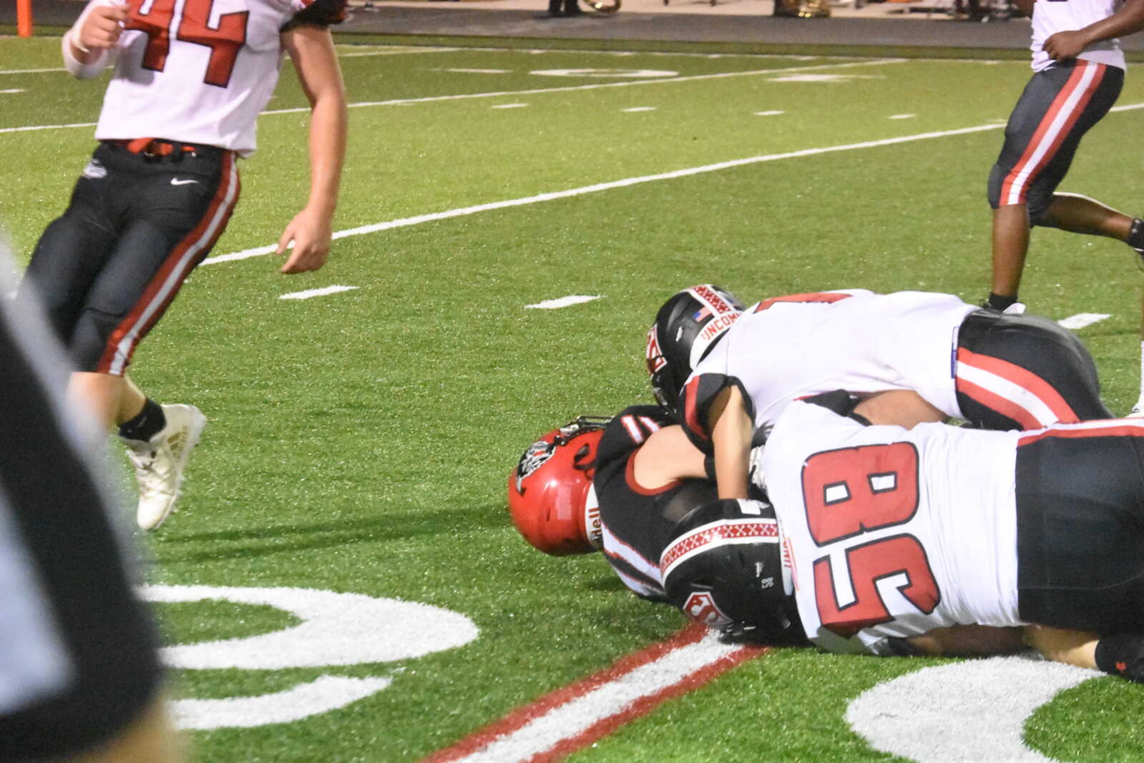 Sikeston's Camden Copeland (58) and a team mate bring down Dexter's Logan Josupait (11).