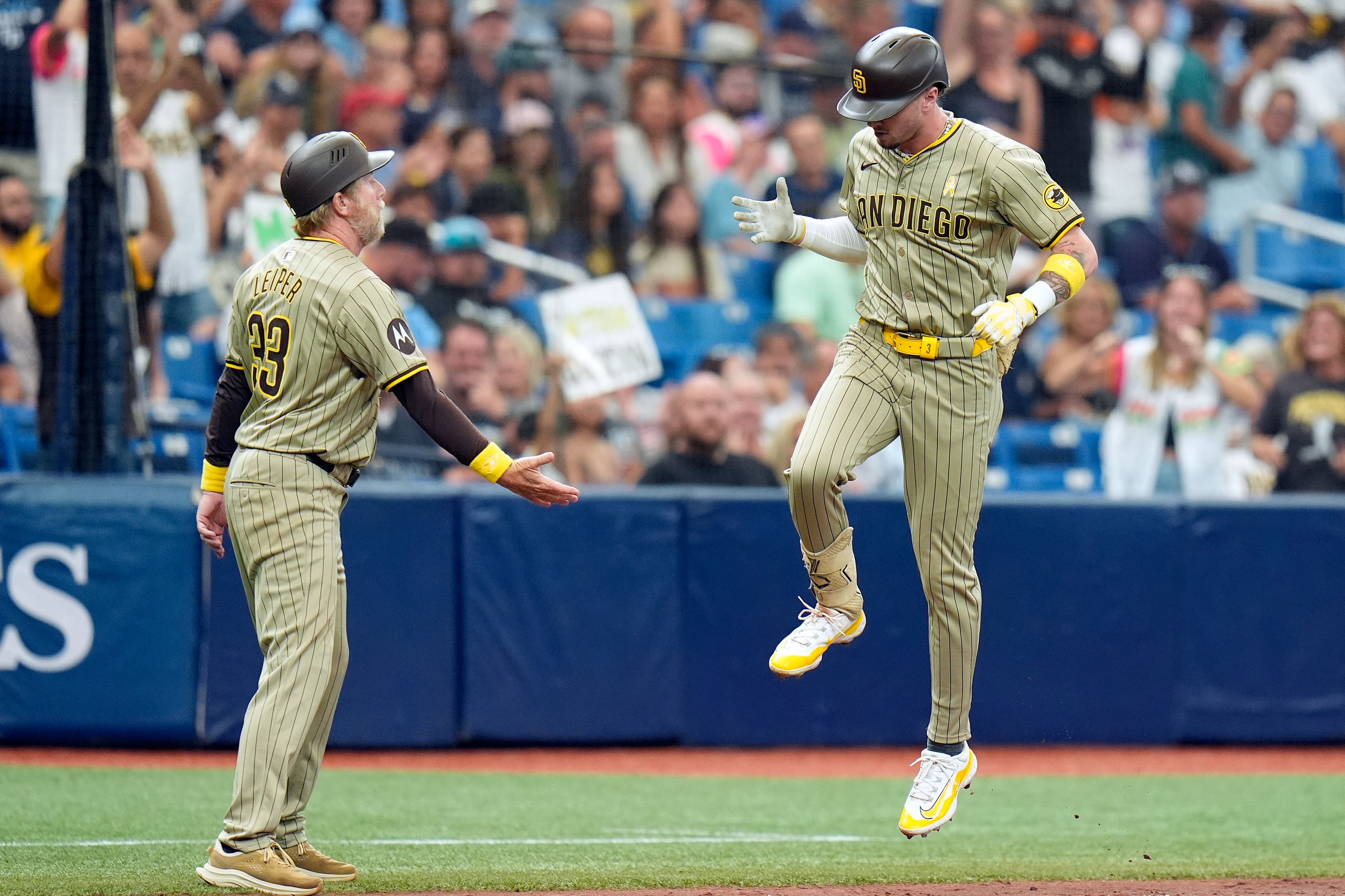 San Diego Padres' Jackson Merrill celebrates with third base coach Tim Leiper (33) after his two-run home run off Tampa Bay Rays starting pitcher Ryan Pepiot during the fourth inning of a baseball game Sunday, Sept. 1, 2024, in St. Petersburg, Fla. (AP Photo/Chris O'Meara)