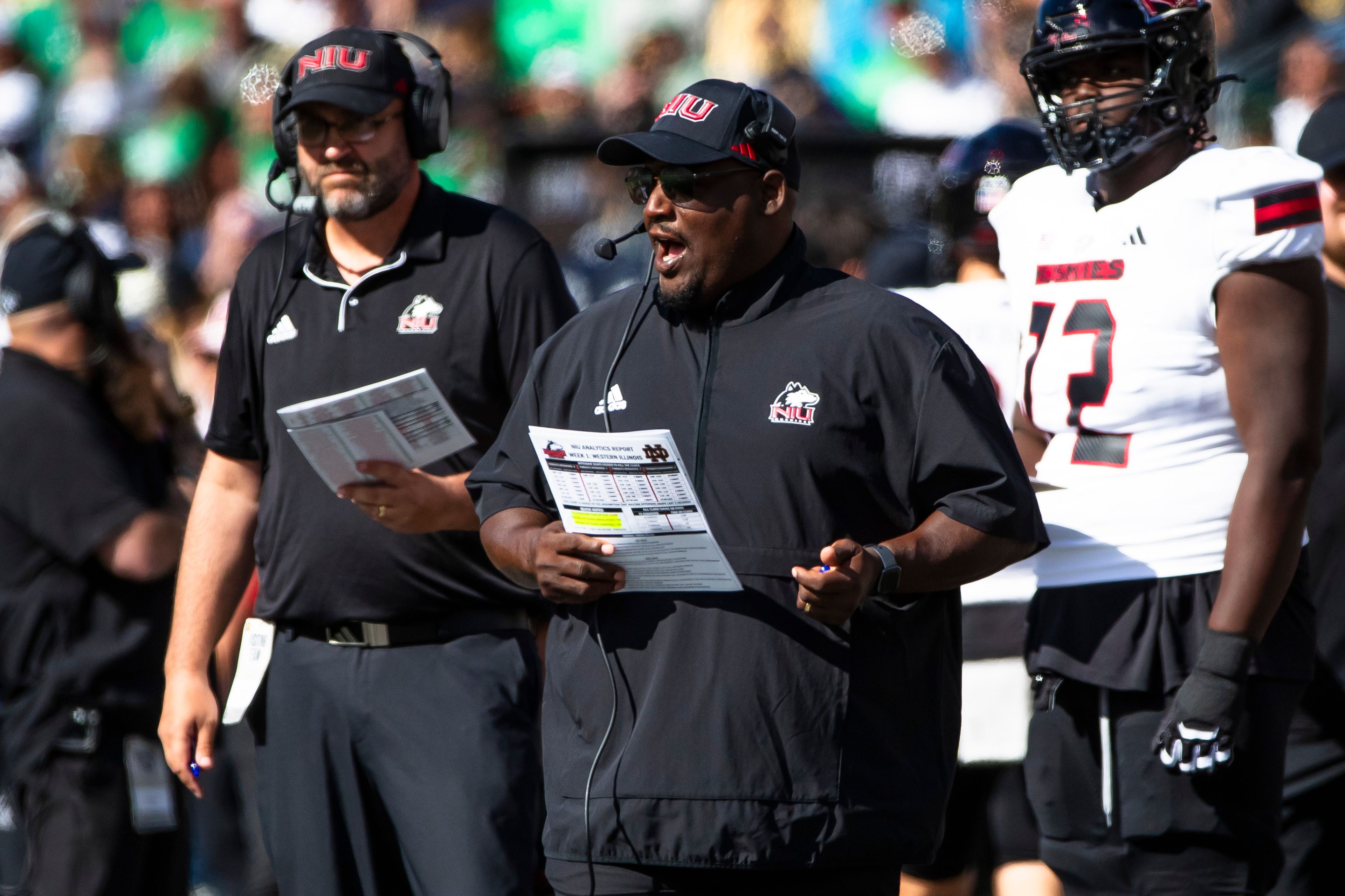 Northern Illinois head coach Thomas Hammock, center, talks into his headset during an NCAA college football game against Notre Dame, Saturday, Sept. 7, 2024, in South Bend, Ind. (AP Photo/Michael Caterina)