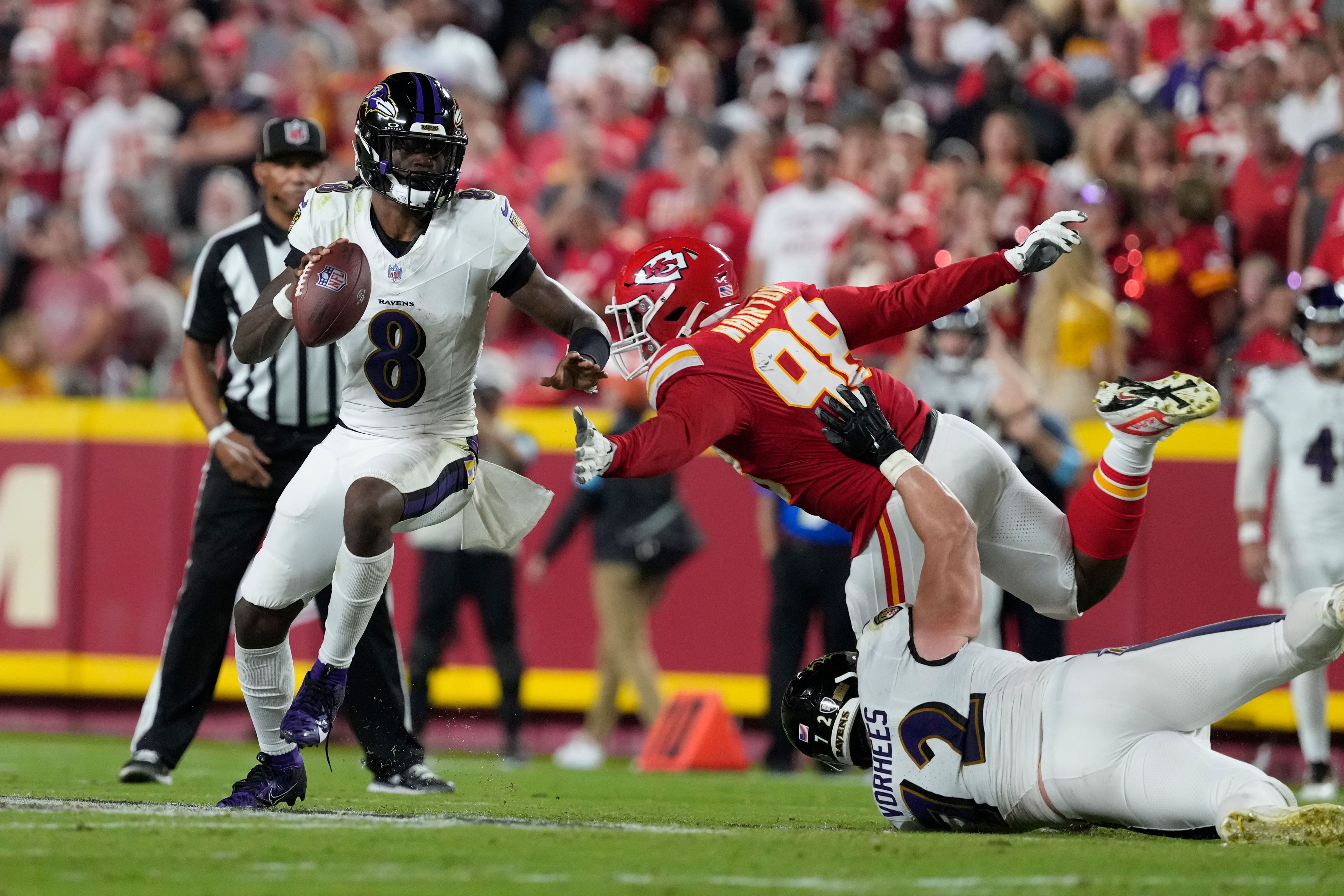 Baltimore Ravens quarterback Lamar Jackson (8) scrambles as Kansas City Chiefs defensive tackle Tershawn Wharton (98) defends during the first half of an NFL football game Thursday, Sept. 5, 2024, in Kansas City, Mo. (AP Photo/Ed Zurga)