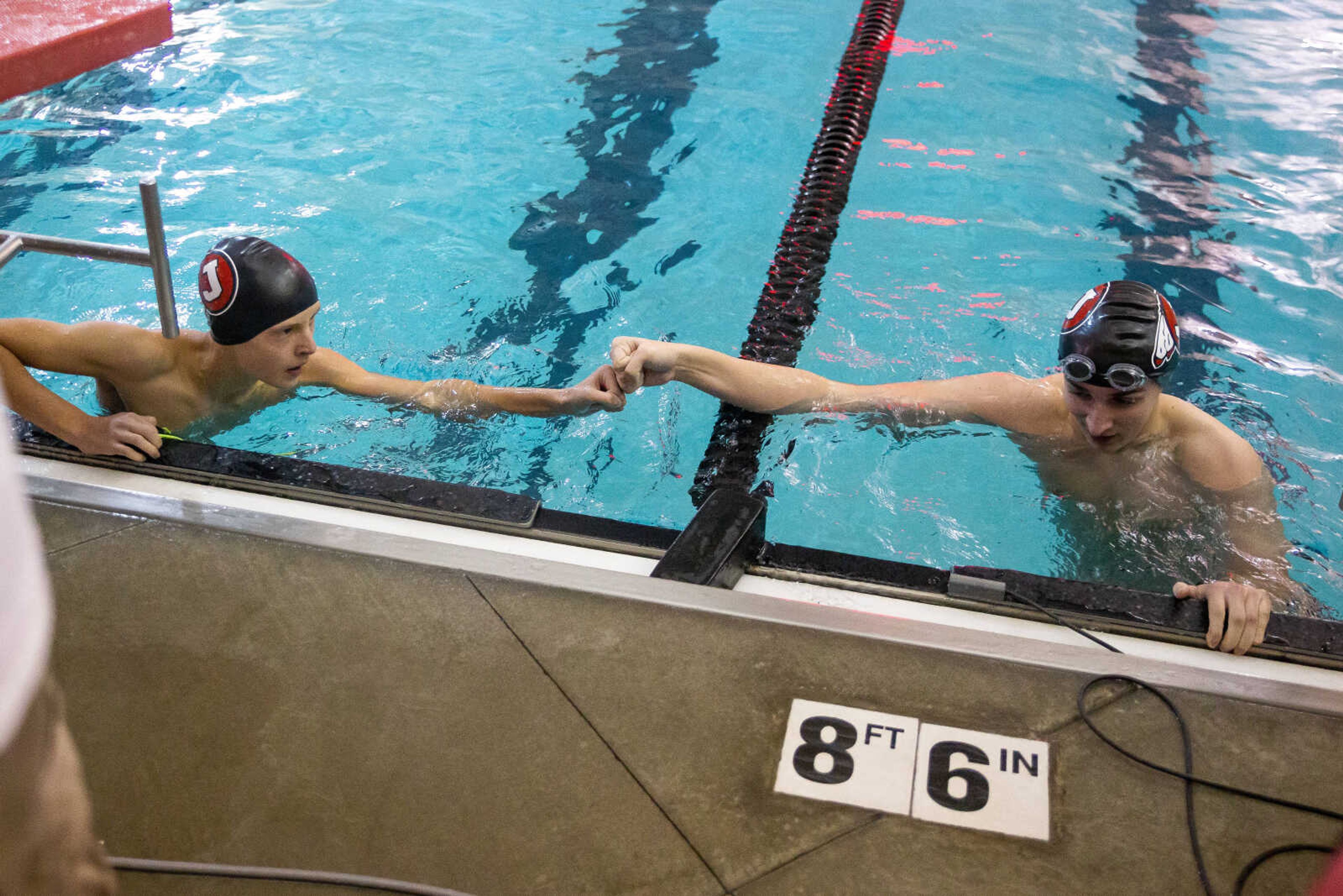 Jackson's Timothy Deyong, right, fist bumps teammate Jan Handke after completing the 100-yard backstroke at the SEMO conference swim meet on Tuesday at the Southeast Missouri State University Student Aquatic Center in Cape Girardeau.