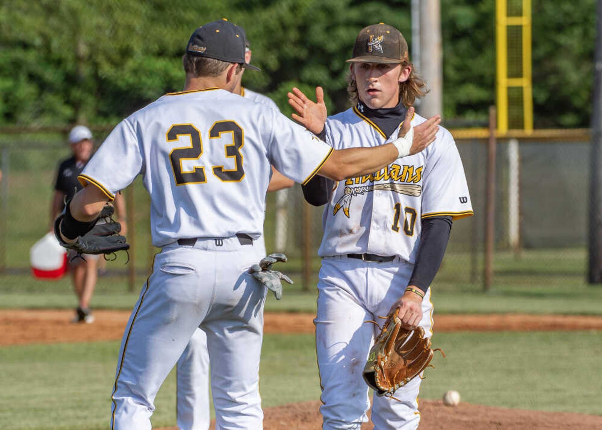 Kennett's J.C. Poole (23) high fives pitcher Ashton Williams (10) after winning a Missouri State High School Activities Association Class 4 State Sectional against Potosi at Indian Park in Kennett on Tuesday, May 23, 2023.