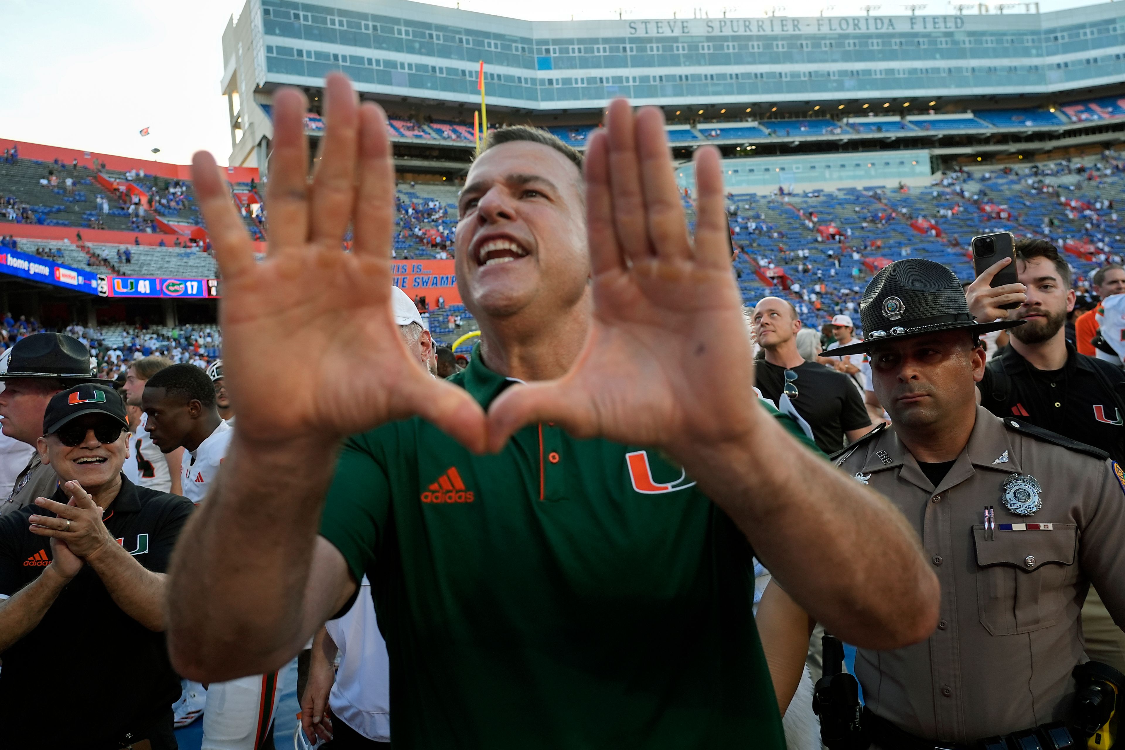 Miami head coach Mario Cristobal makes the sign of the U to cheering fans as he leaves the field after defeating Florida in an NCAA college football game, Saturday, Aug. 31, 2024, in Gainesville, Fla. (AP Photo/John Raoux)