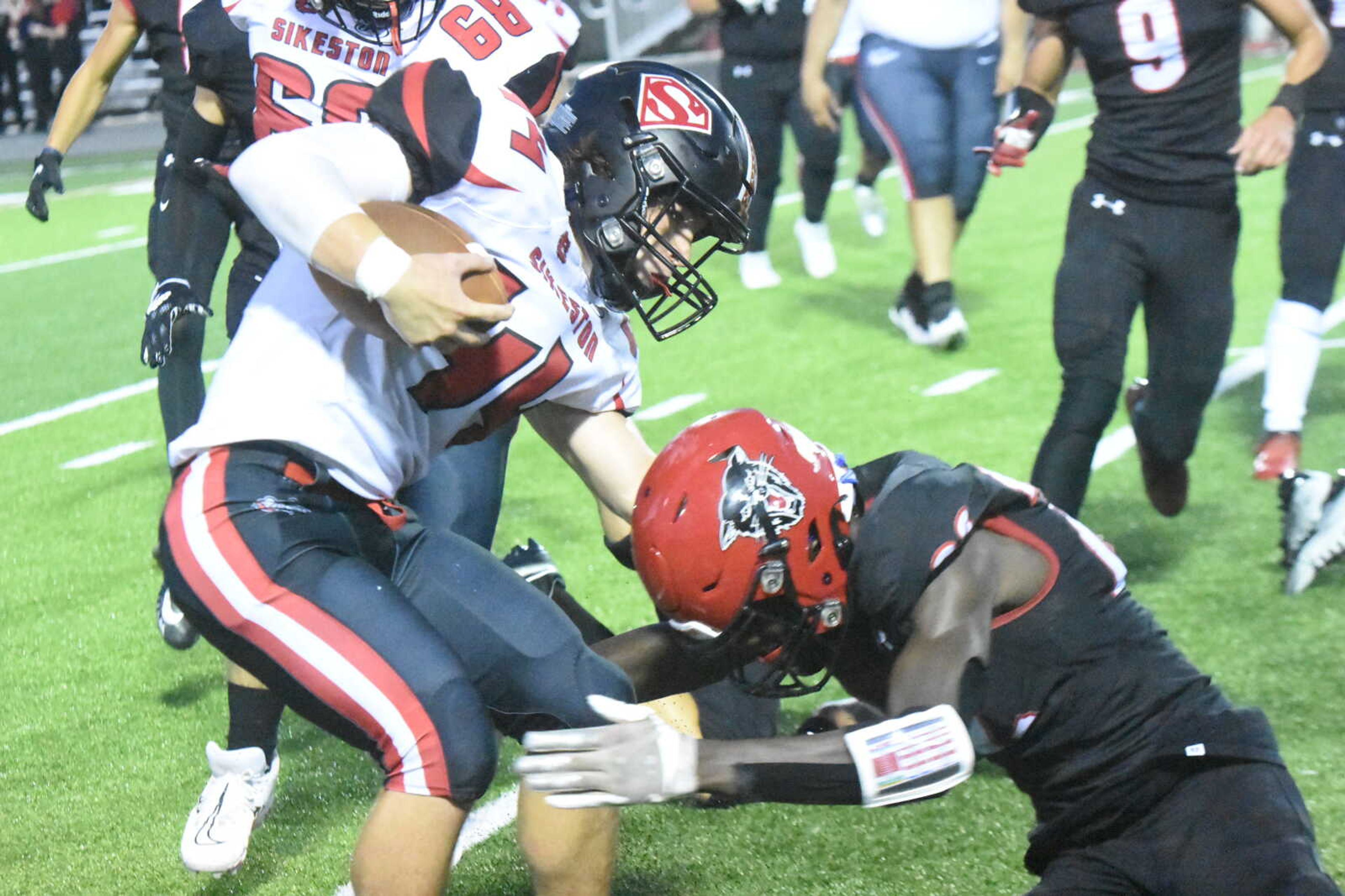 Sikeston's Luke Gadberry (44) trys to elude the tackle of Dexter's Jaxen Grams.