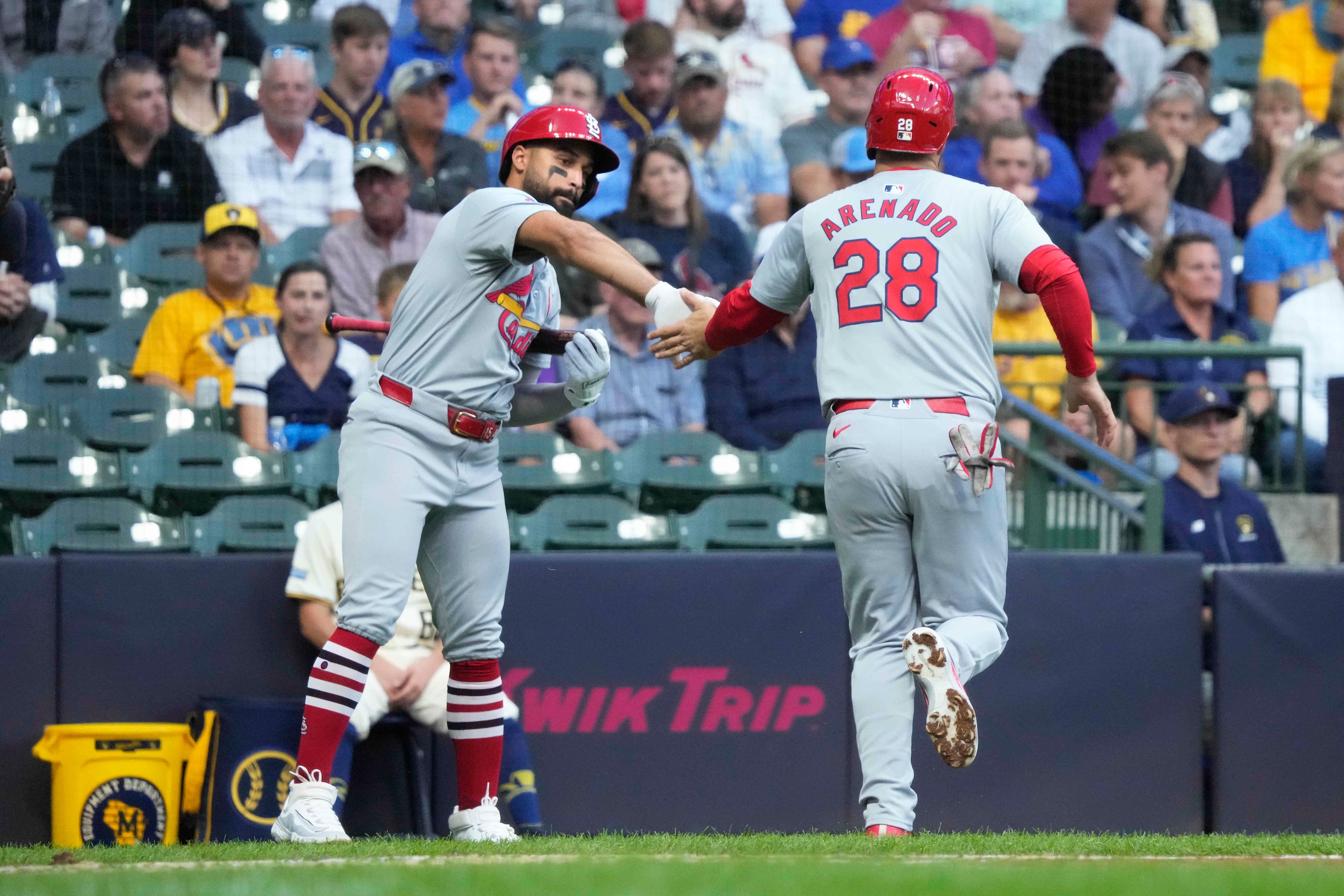 St. Louis Cardinals' José Fermín, left, high-fives Nolan Arenado (28) after Arenado scored on a bases-loaded walk in the first inning of a baseball game against the Milwaukee Brewers, Wednesday, Sept. 4, 2024, in Milwaukee. (AP Photo/Kayla Wolf)