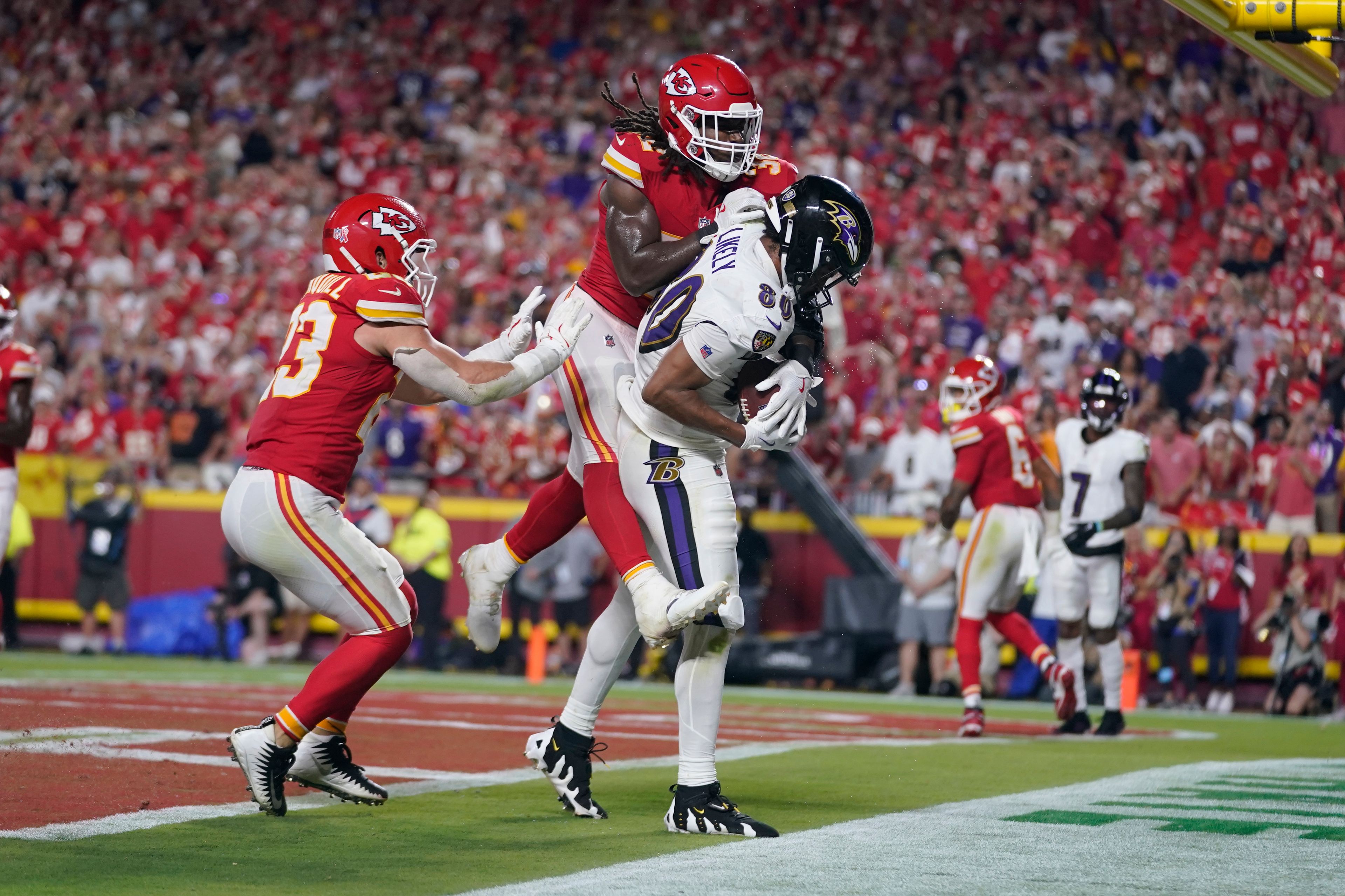 Baltimore Ravens tight end Isaiah Likely (80) catches a pass with his toe out of bounds as Kansas City Chiefs linebacker Nick Bolton and linebacker Drue Tranquill, left, defend as time time expires in the second half of an NFL football game Thursday, Sept. 5, 2024, in Kansas City, Mo. The Chiefs won 27-20.(AP Photo/Ed Zurga)