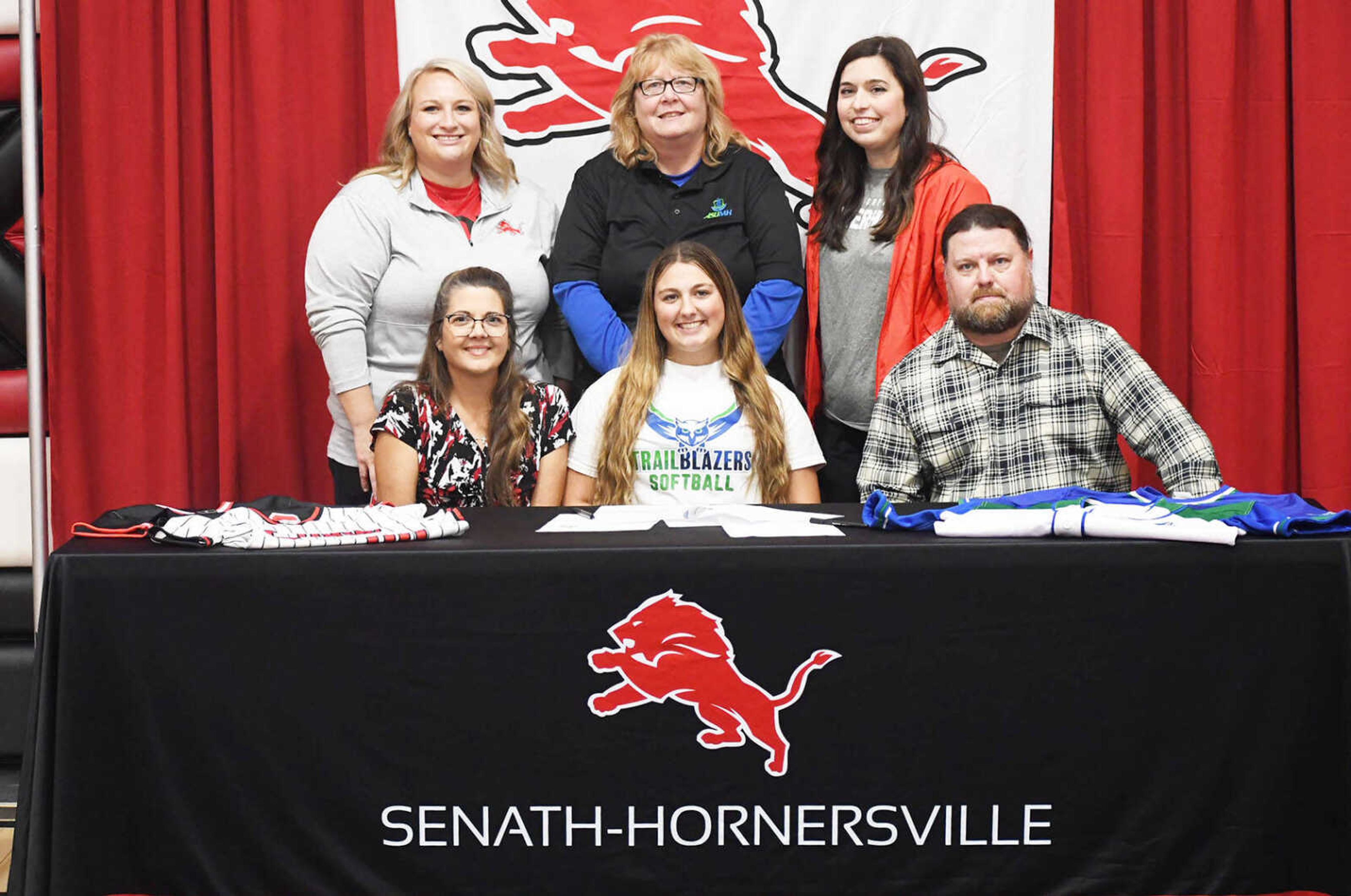 Senath-Hornersville’s Kaya Horton (bottom row, center) is all smiles after signing to continue her softball career at Arkansas State University-Mountain Home on Friday. Kaya is flanked by her mother and father, Keythlea and Billy, and in the back row, from left, Senath-Hornersville assistant softball coach Allyson Conley, ASU-Mountain Home head coach JoAnn Baeten and Lions head coach Melani Rooney. 