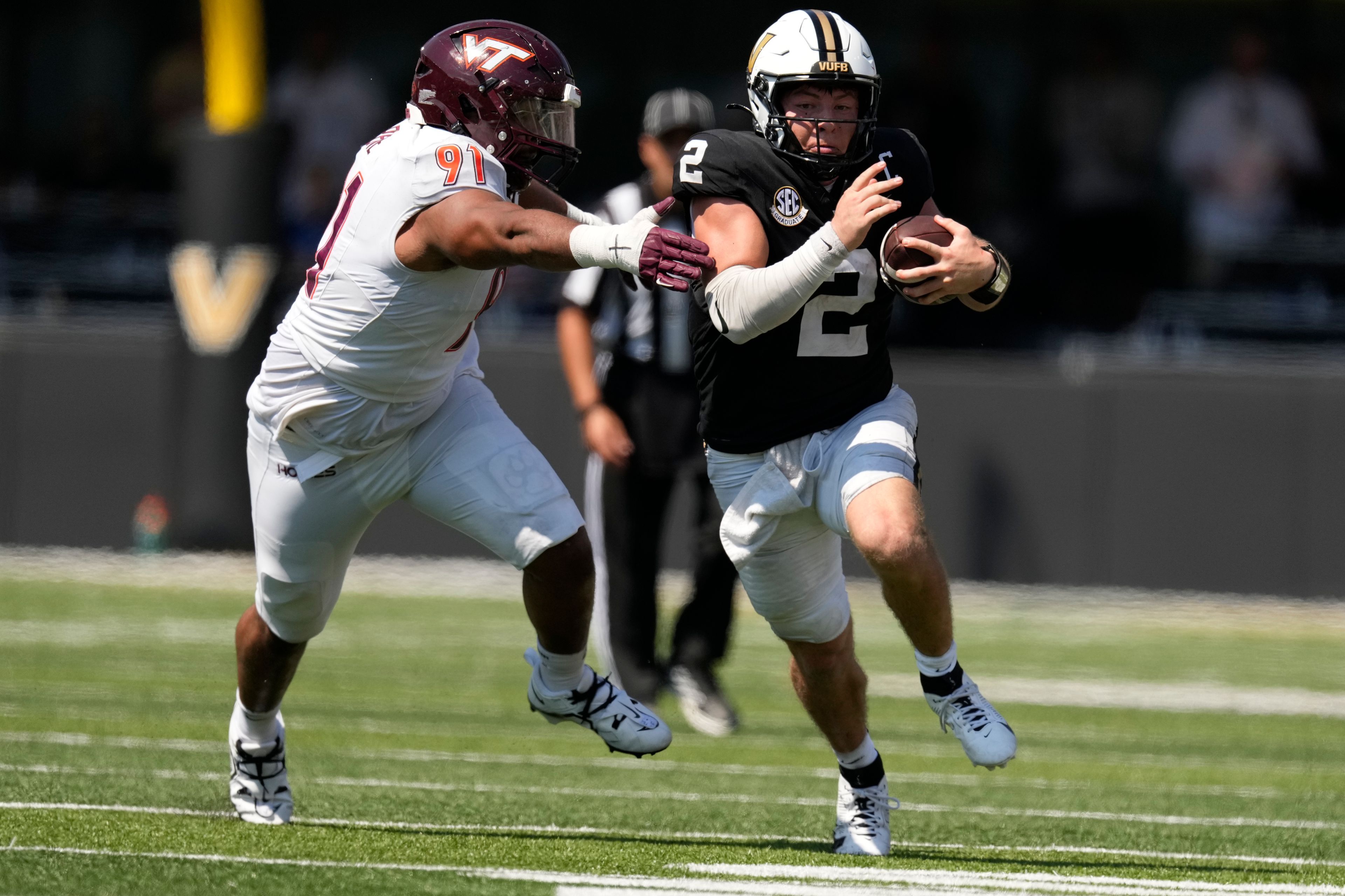 Vanderbilt quarterback Diego Pavia (2) runs the ball past Virginia Tech defensive lineman Wilfried Pene (91) during the second half of an NCAA college football game Saturday, Aug. 31, 2024, in Nashville, Tenn. (AP Photo/George Walker IV)