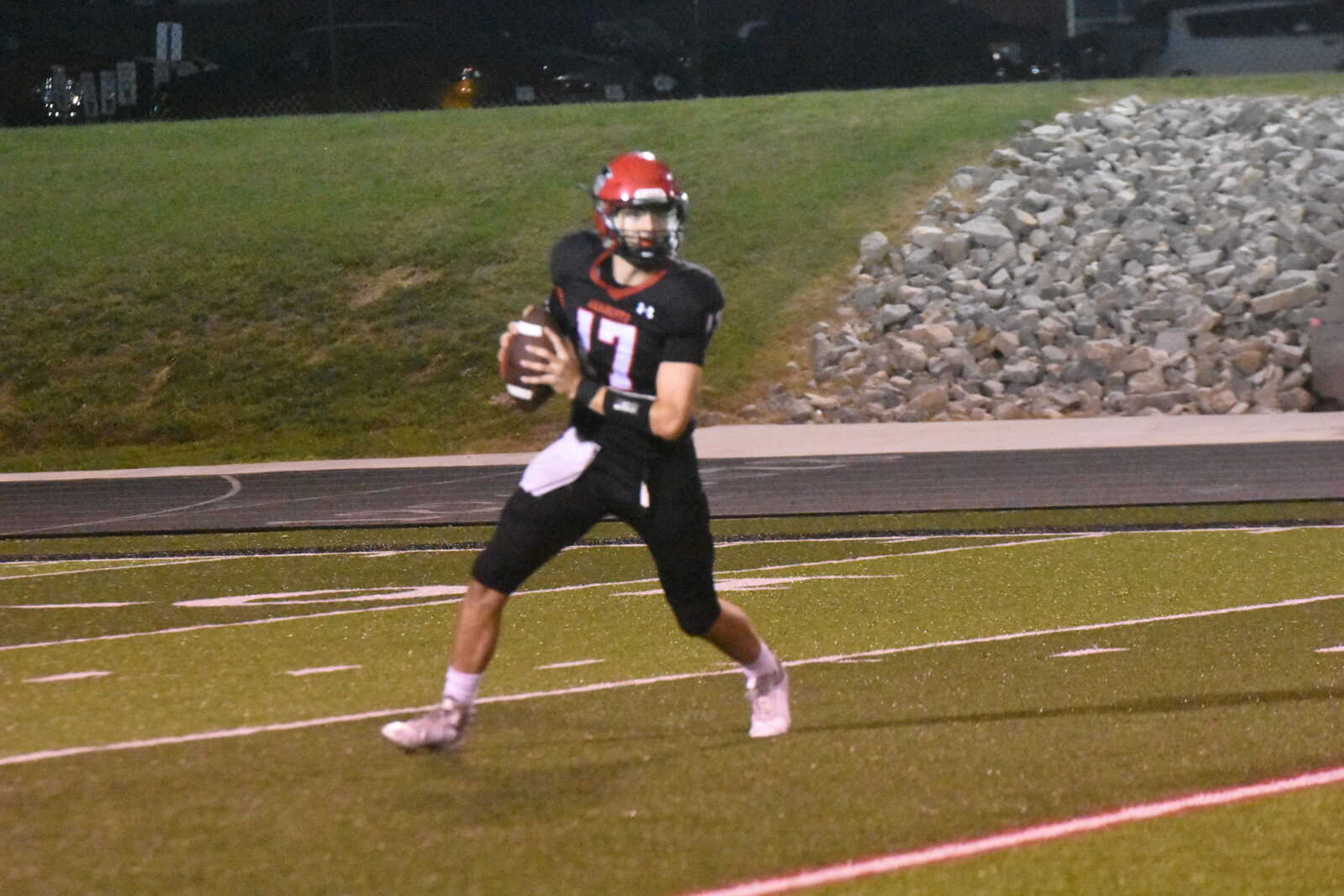 Dexter quarterback Jackson Howard rolls out as he looks downfield for a receiver.