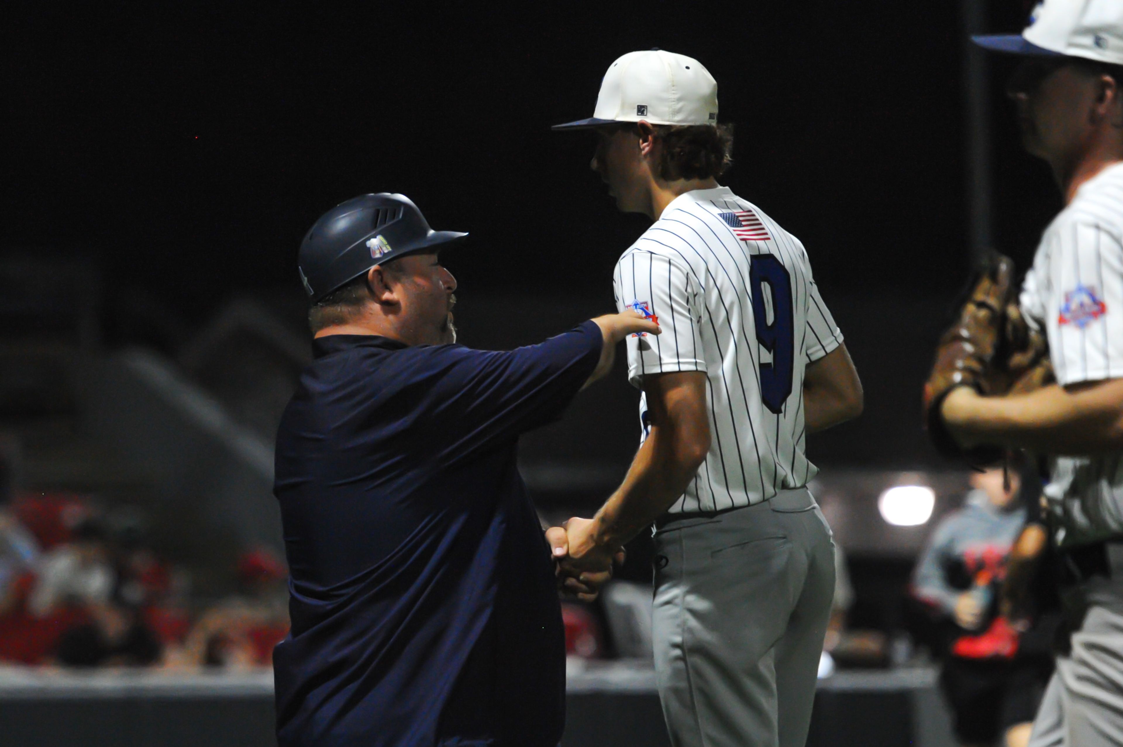 Aycorp coach Michael Minner (left) talks to pitcher Lawson Graff (right) during a Tuesday, August 13, 2024 Babe Ruth World Series game between the Aycorp Fighting Squirrels and Holland Henson of the Netherlands at Capaha Field in Cape Girardeau, Mo. Aycorp defeated the Netherlands, 12-2 in five innings.