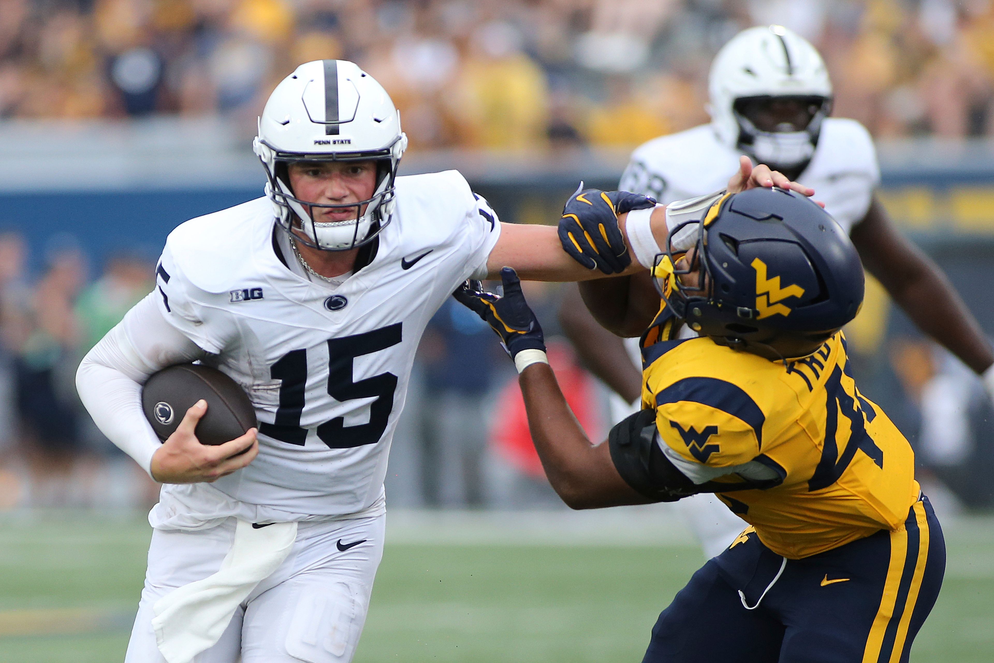 Penn State quarterback Drew Allar (15) is defended by West Virginia linebacker Josiah Trotter (40) during the second half of an NCAA college football game in Morgantown, W.Va., Saturday, Aug. 31, 2024. (AP Photo/Kathleen Batten)