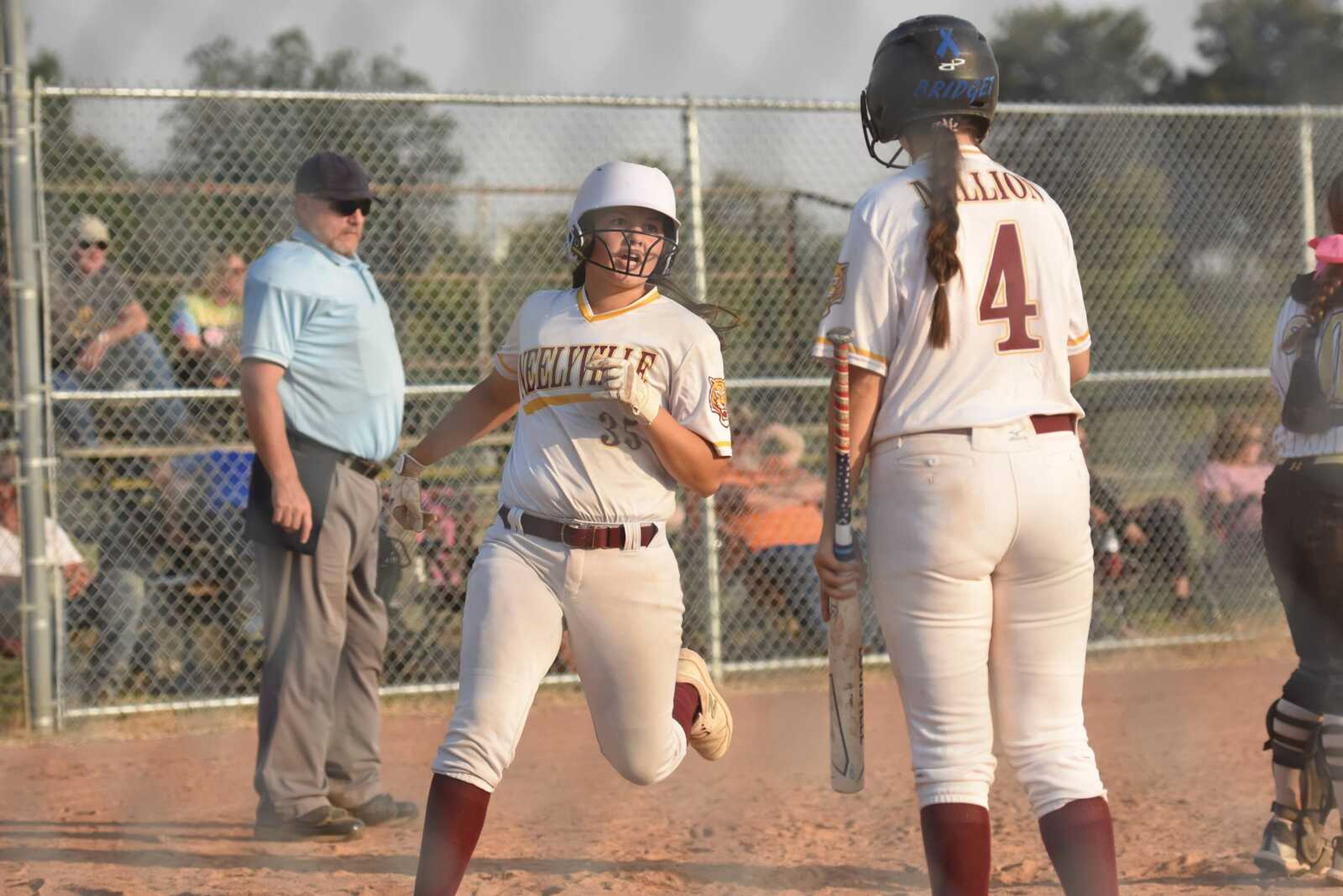 Neelyville's Reese Dobbins (35) crosses home plate while Bridget Million (14) waits for her there during a softball game against Doniphan on Wednesday, Oct. 5, 2022 in Neelyville.