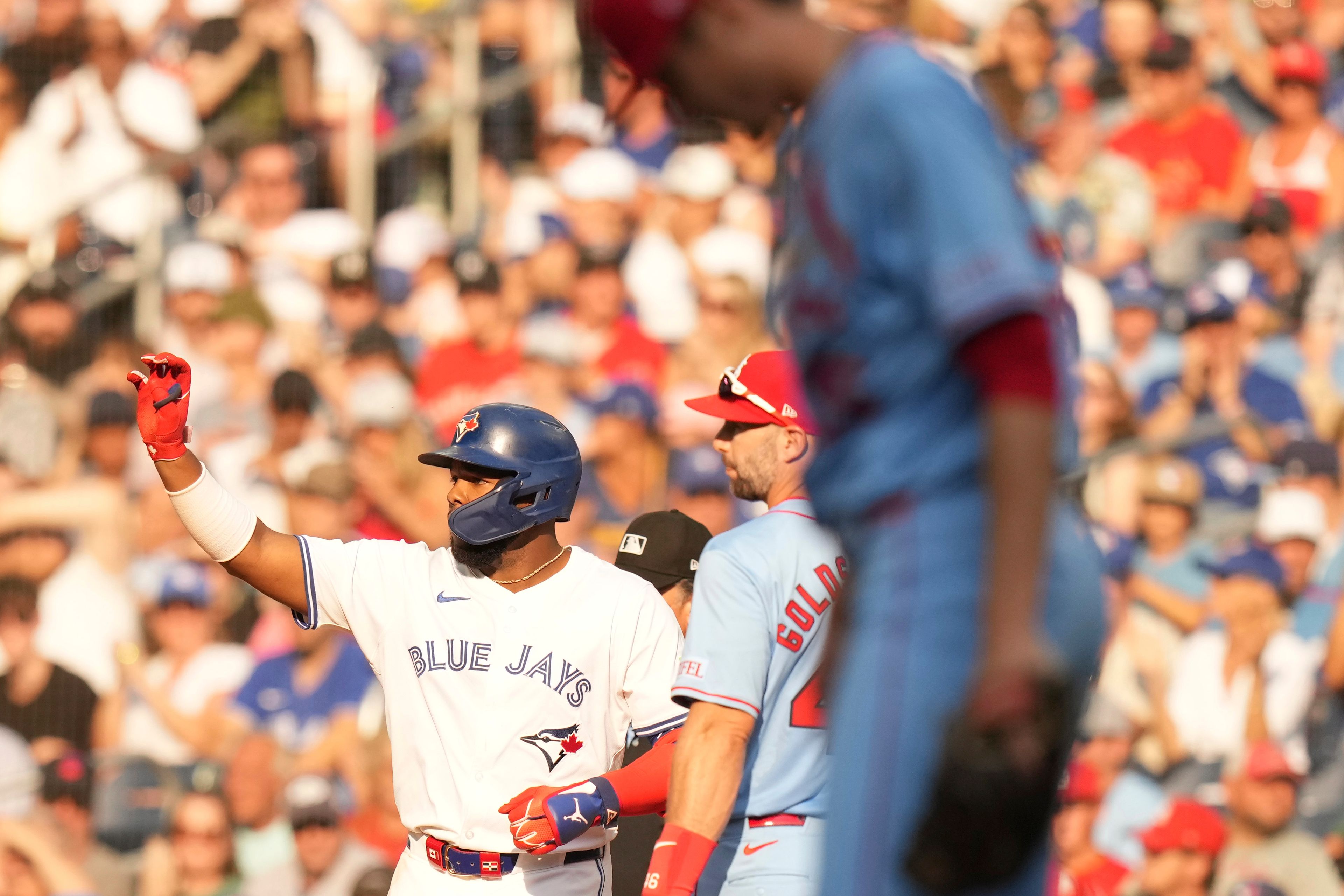 Toronto Blue Jays' Vladimir Guerrero Jr. gestures for the ball after hitting an RBI single, his 500th RBI as a Blue Jay, as he stands with St. Louis Cardinals first baseman Paul Goldschmidt during seventh inning interleague MLB baseball action in Toronto, Saturday, September 14, 2024. (Chris Young/The Canadian Press via AP)