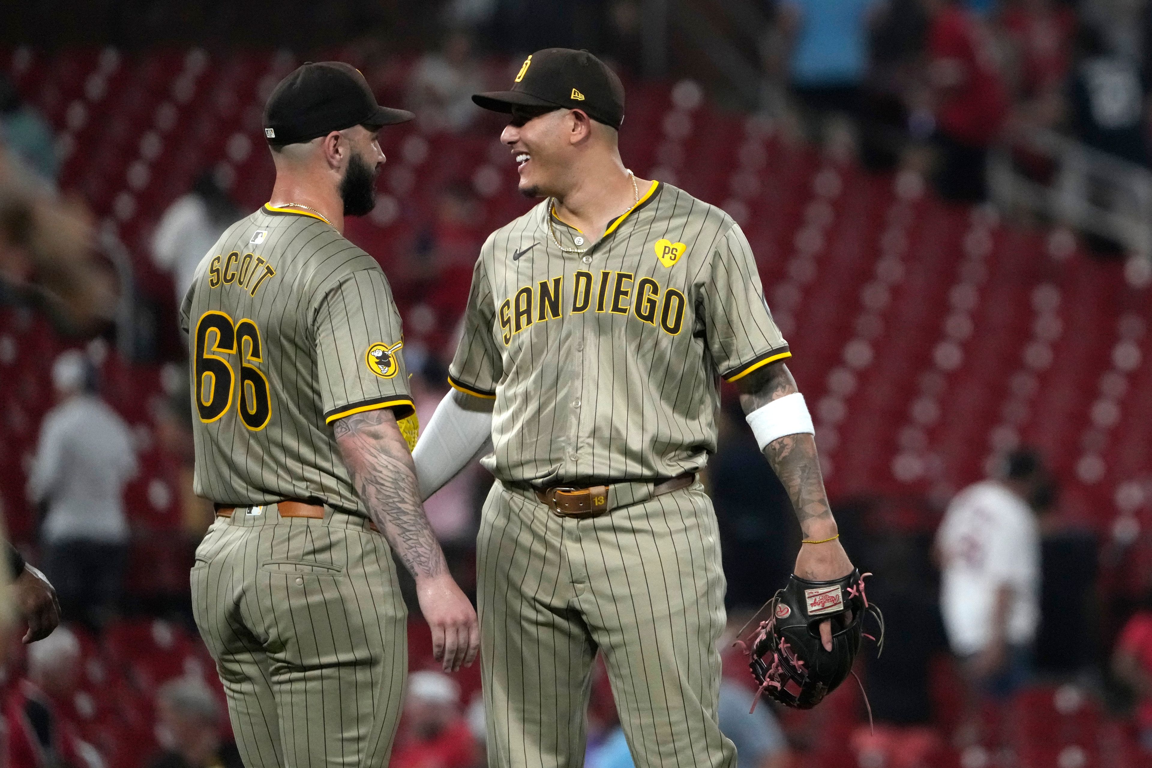 San Diego Padres Tanner Scott and teammate Manny Machado celebrate a 7-5 victory over the St. Louis Cardinals in a baseball game Tuesday, Aug. 27, 2024, in St. Louis. (AP Photo/Jeff Roberson)