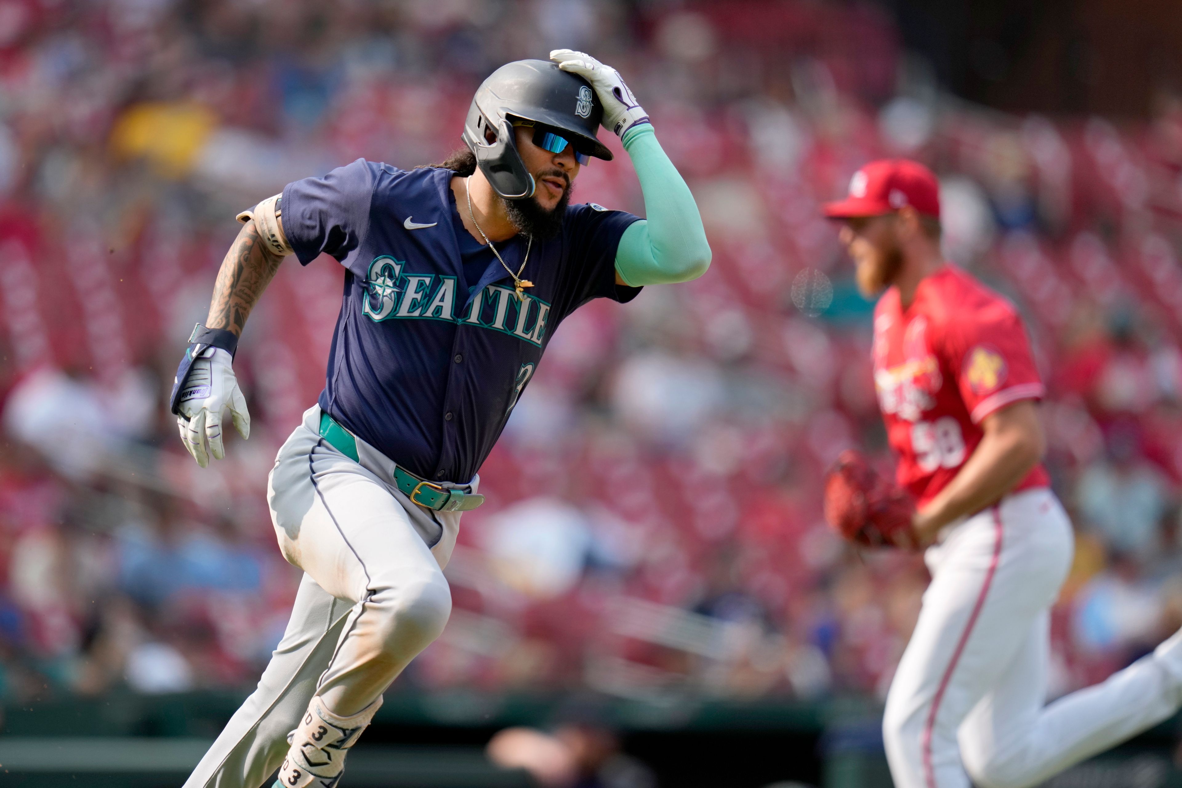 Seattle Mariners' J.P. Crawford, left, rounds first on his way to an RBI double off St. Louis Cardinals pitcher Chris Roycroft, right, during the ninth inning of a baseball game Sunday, Sept. 8, 2024, in St. Louis. (AP Photo/Jeff Roberson)