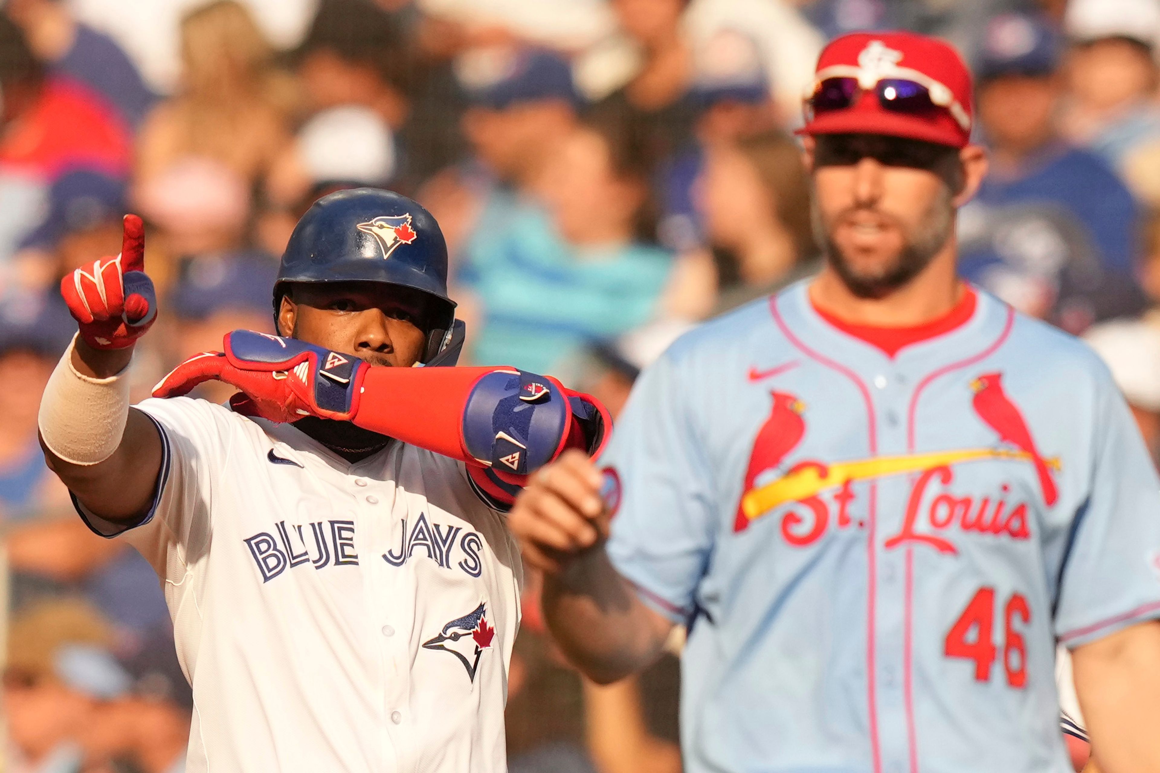 Toronto Blue Jays' Vladimir Guerrero Jr. gestures to the bench as he stands alongside St. Louis Cardinals first baseman Paul Goldschmidt after hitting an RBI single during seventh inning interleague MLB baseball action in Toronto, Saturday, September 14, 2024. (Chris Young/The Canadian Press via AP)