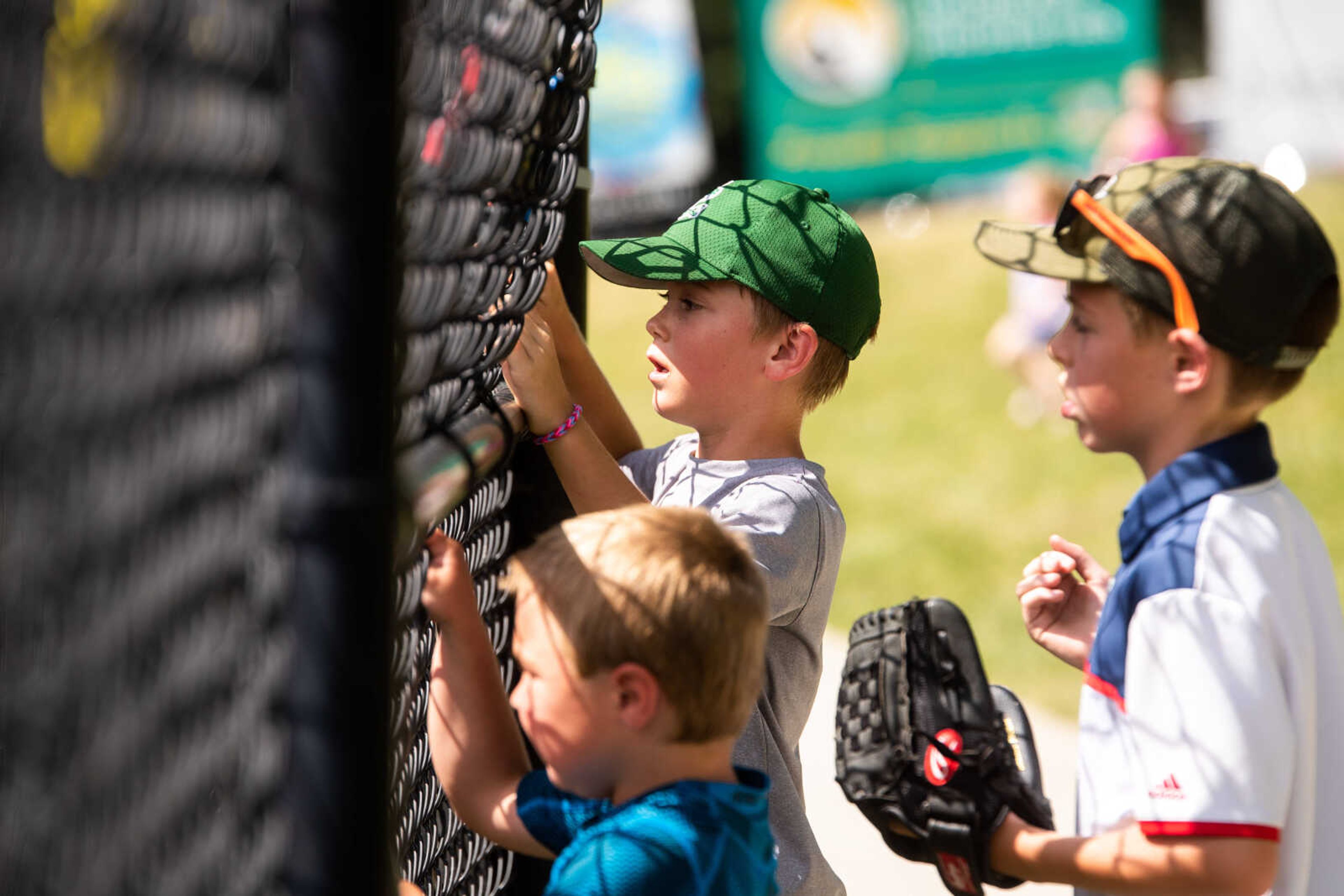 Young Catfish fans peer through the chainlink fence during the game.