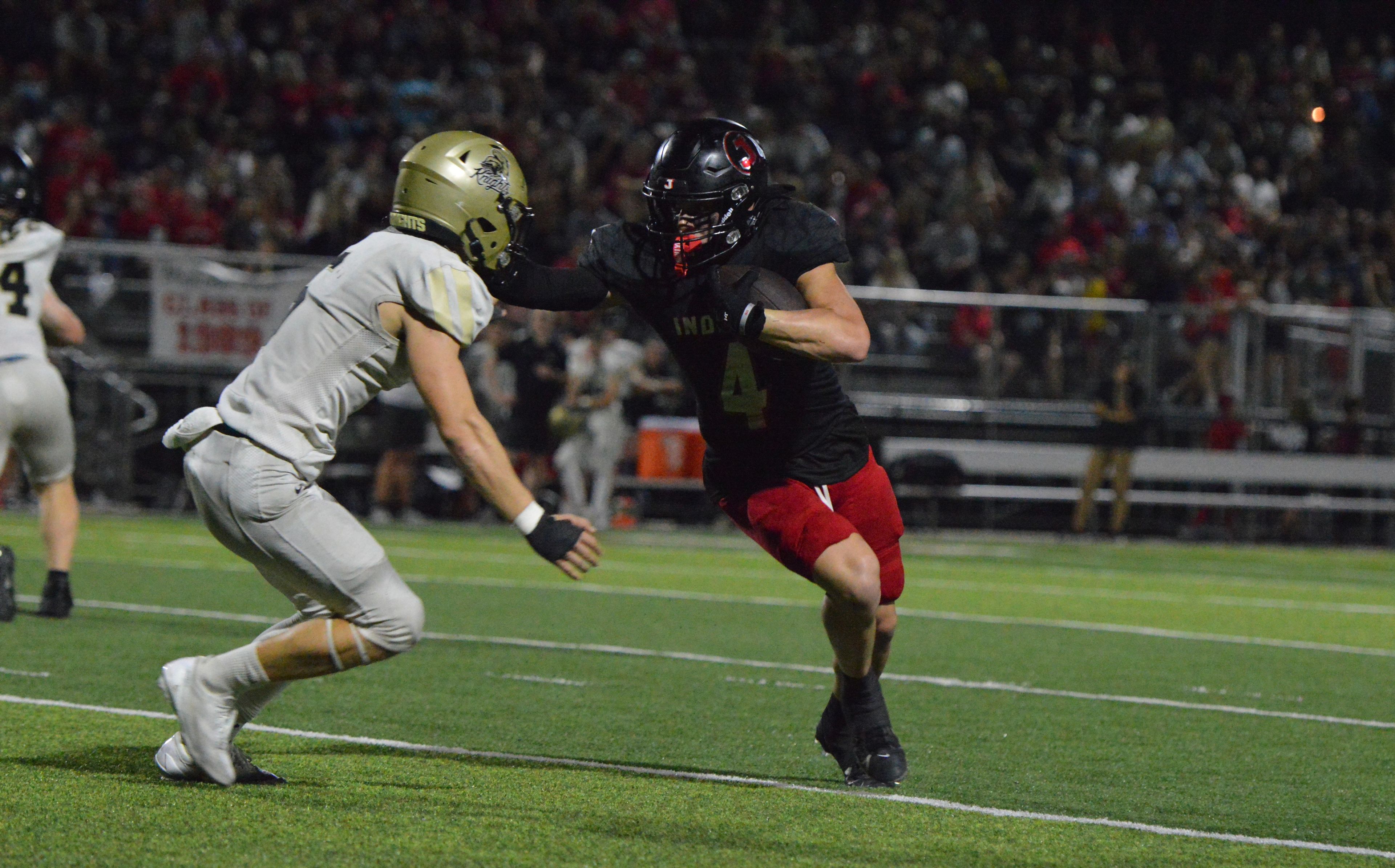 Jackson wide receiver Kai Crowe stiff arms a Farmington defender in the fourth quarter of the home opener on Friday, Sept. 20.