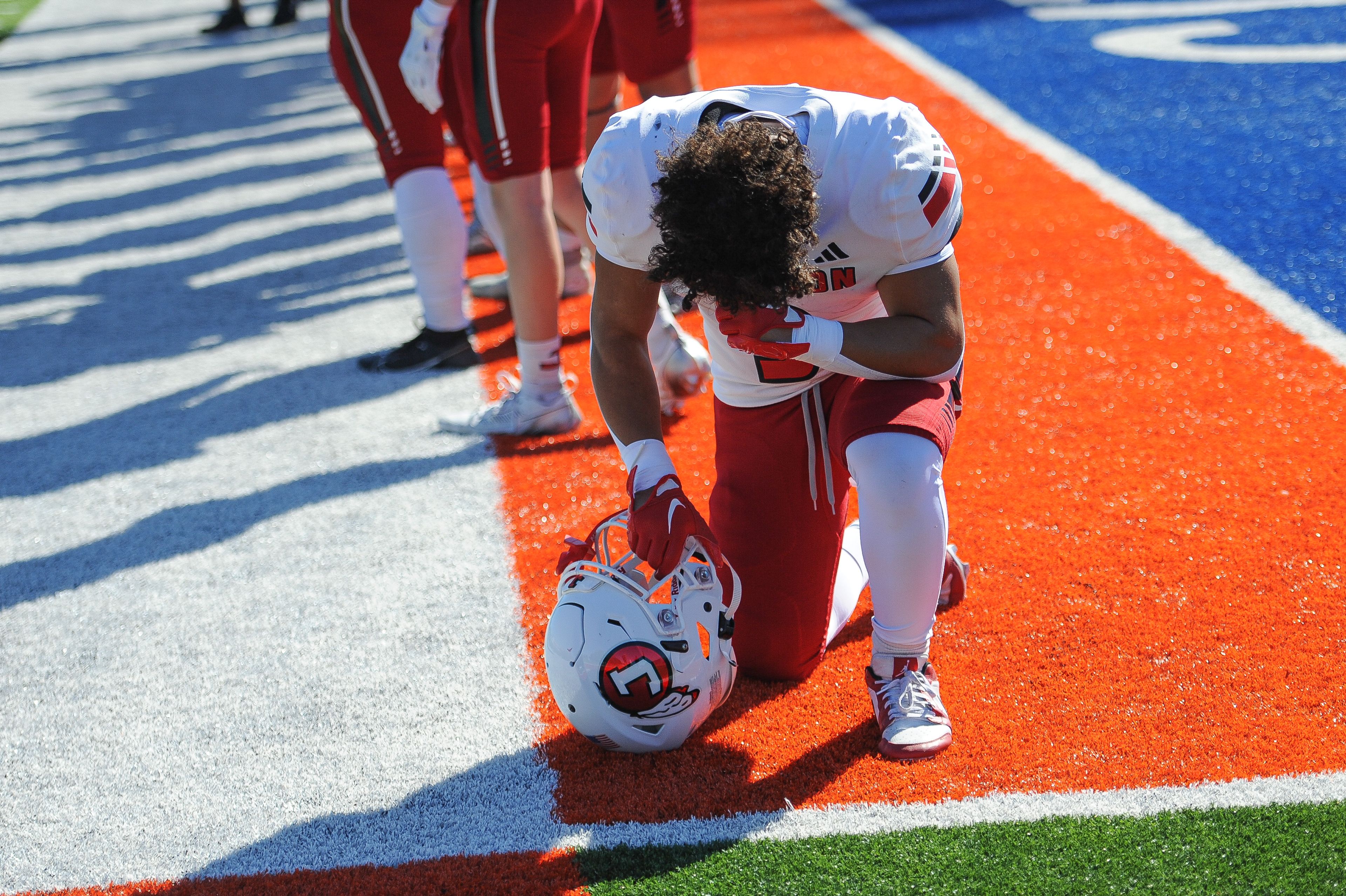 Jackson's Jaylon Hampton kneels to pray before a Saturday, September 7, 2024 game between the Jackson Indians and the Cahokia Comanches at East St. Louis Senior High School in East St. Louis, Ill. Jackson defeated Cahokia, 49-26.