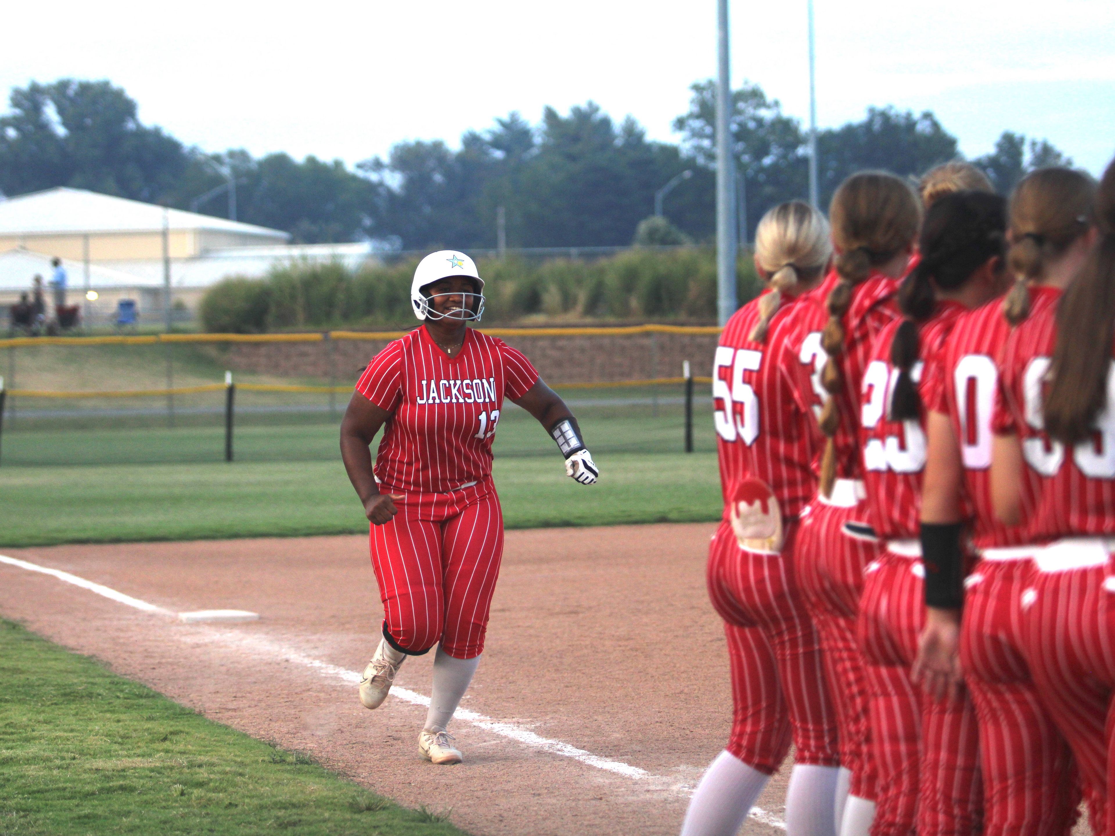 Jackson softball players meet Kimmora Carothers at home plate after she hit a home run in the Jackson Softball Tournament at the Shawnee Park Center in Cape Girardeau, Mo.
